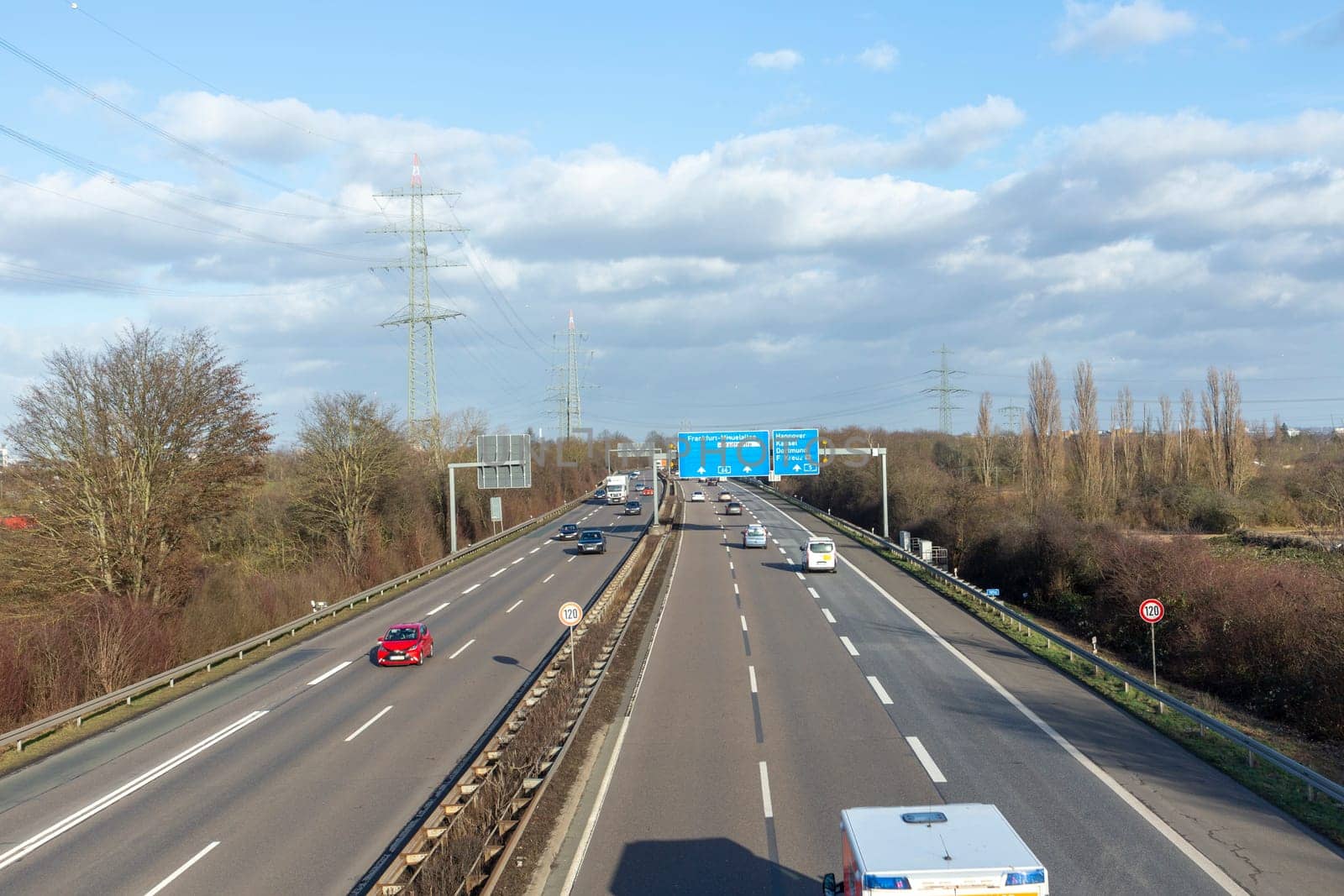 Frankfurt, Germany - January 28, 2022: view to german highway A5 with speed reduction to 120 km and blue signage for next exit.