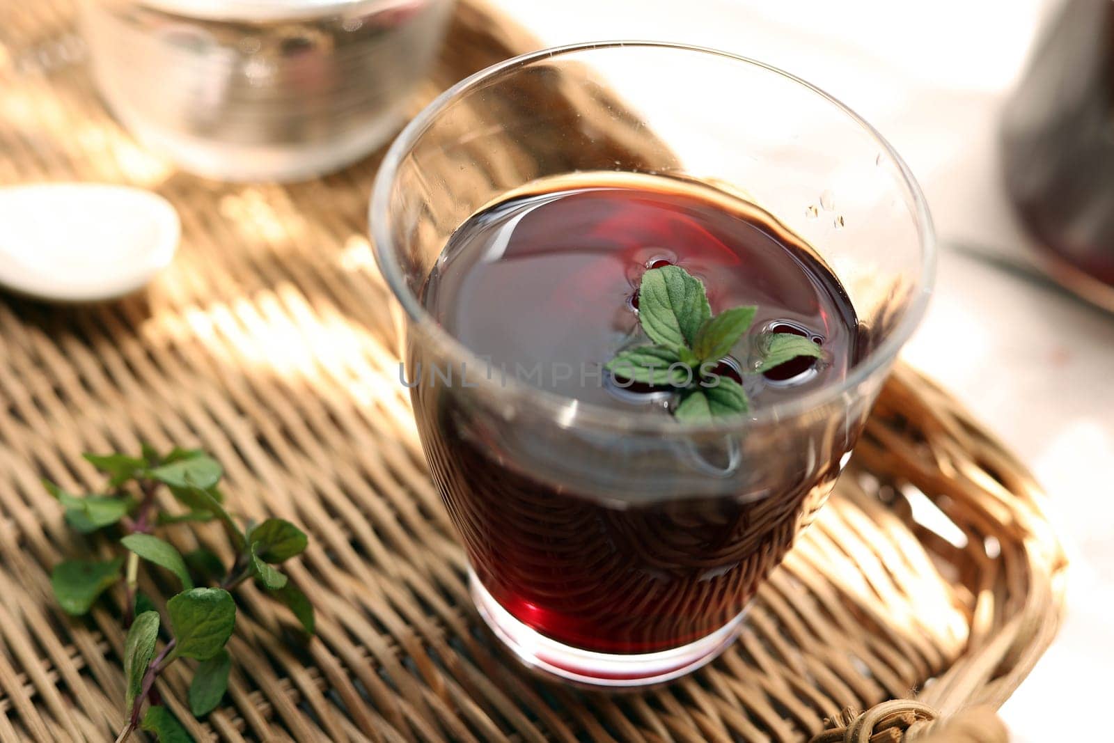 Grape juice poured into a glass on a rattan tray