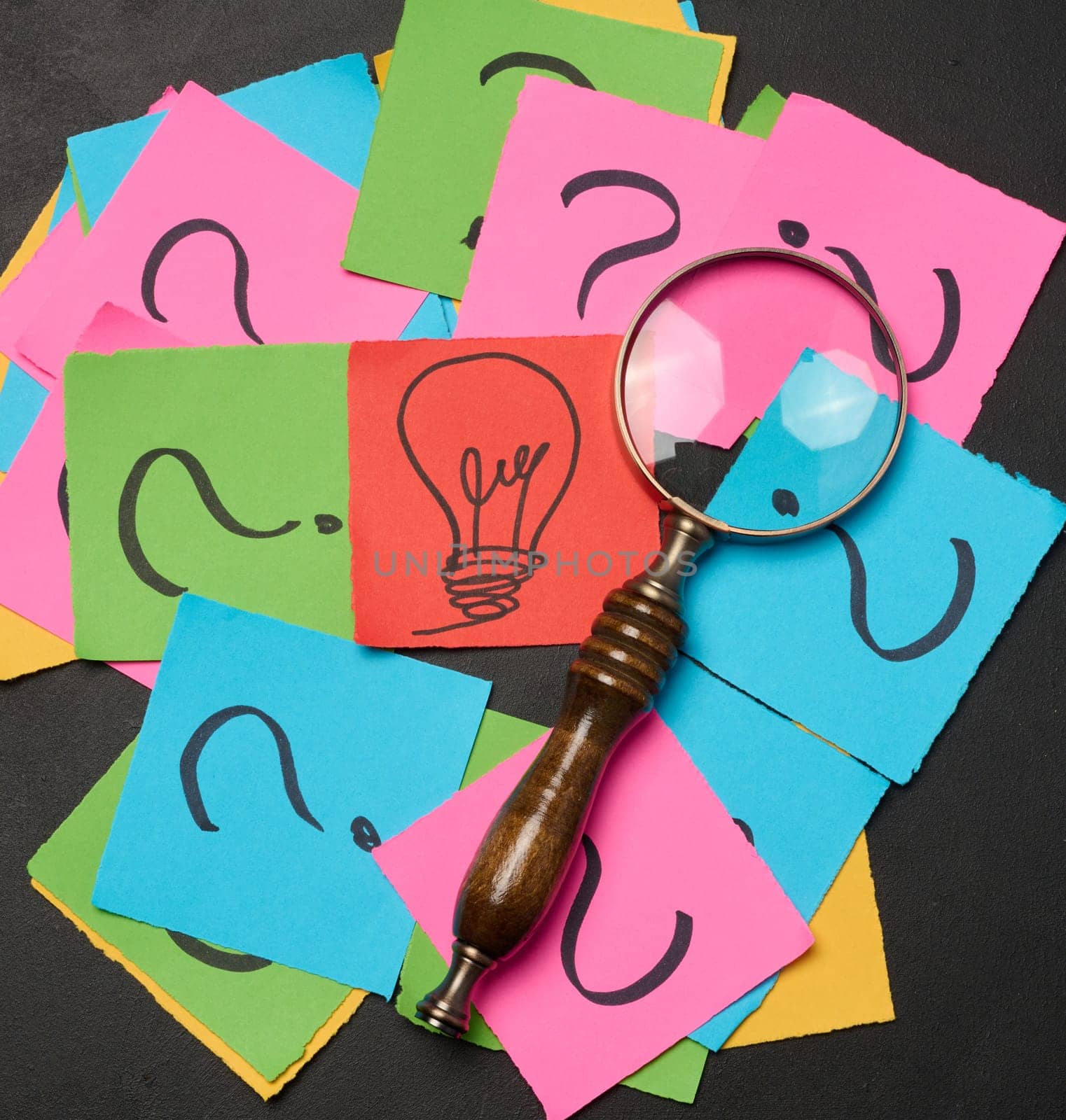 Drawn light bulbs on sheets of paper and a magnifying glass, the concept of searching for new ideas