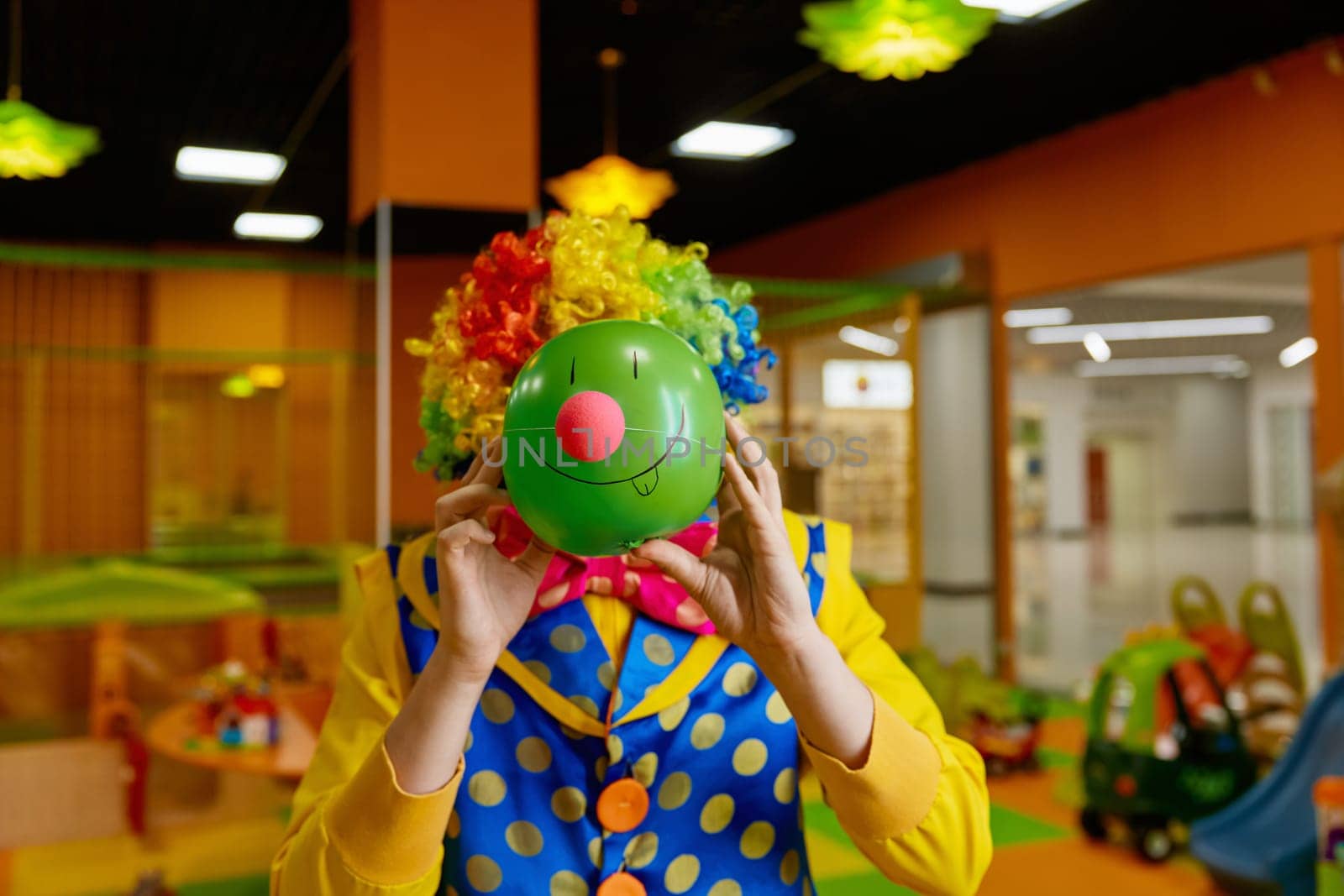 Funny birthday artistic entertainment concept. Portrait of playful clown making face with cute grimace drawn on ball with cute nose