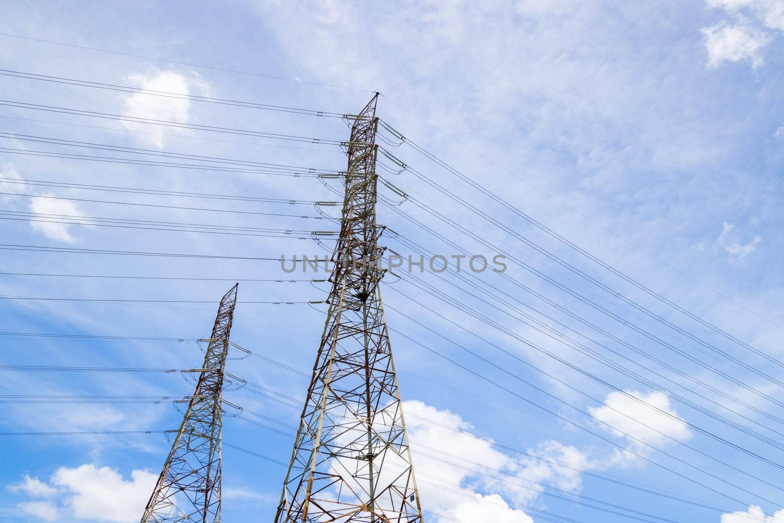 High voltage power line and pylon on blue sky