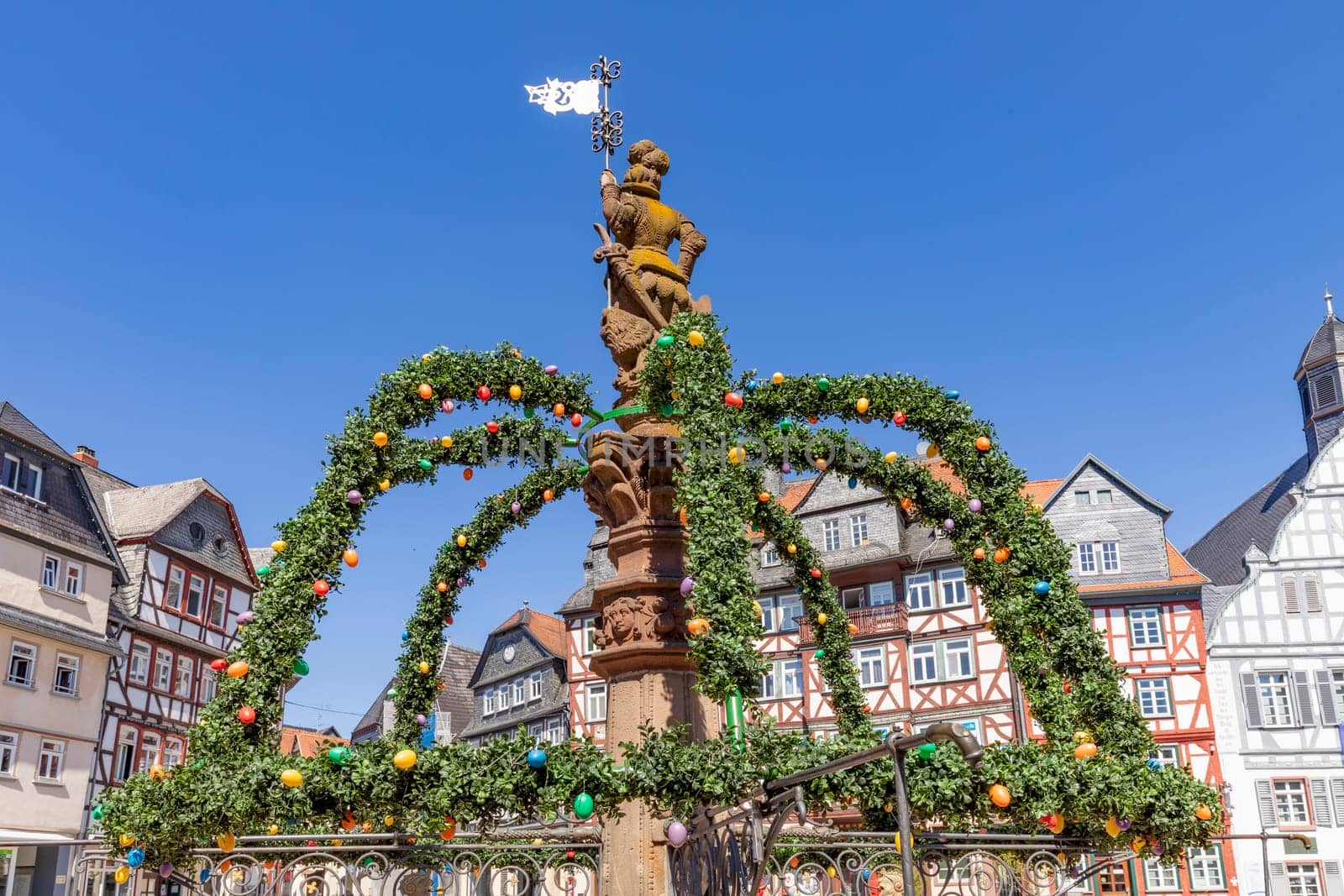 Butzbach, Germany - April 18, 2022:  market square with easter decoration at fountain in the old town of butzbach Germany.