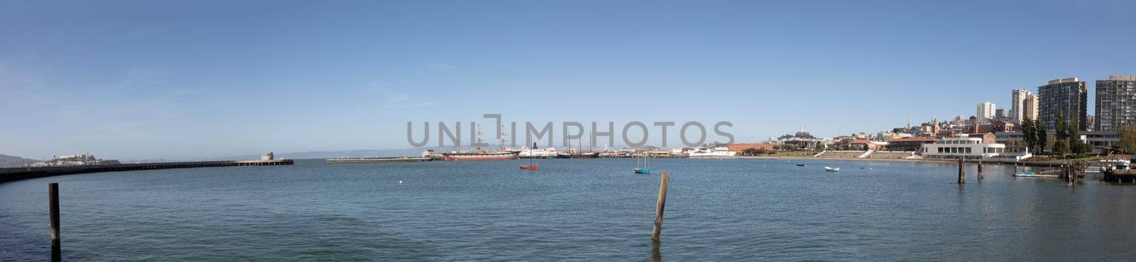 San Francisco, USA - May 18, 2022: panoramic view to fishermans wharf area in San Francisco with skyline and old traditional boats at Hyde street pier.
