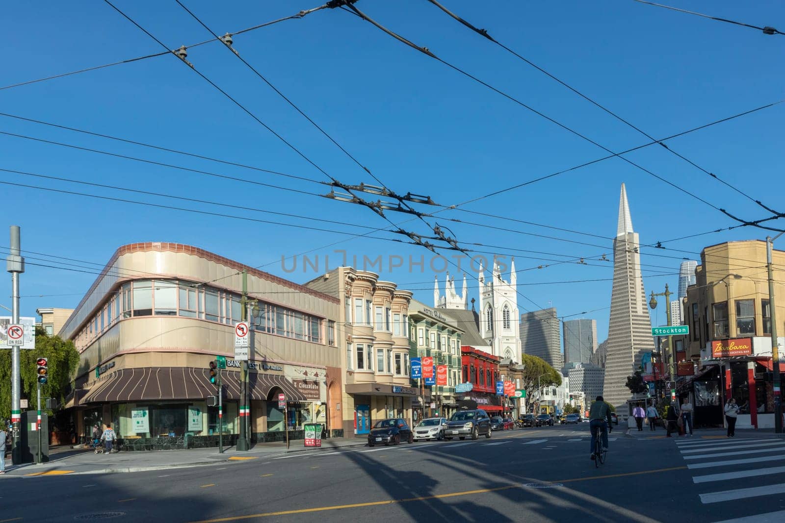 San Francisco, USA - May 18, 2022:  old houses in downtown San Francisco in bright light with view to transamerica pyramid.