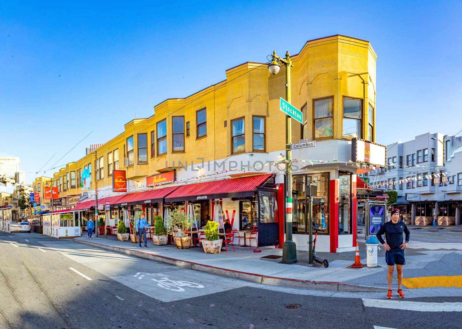San Francisco, USA - May 18, 2022:  old houses in downtown San Francisco in bright light at crossing stockton, Columbus street.