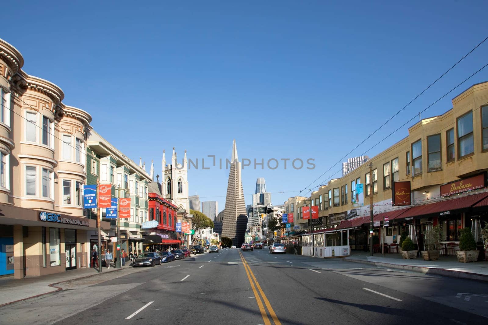 San Francisco, USA - May 18, 2022:  old houses in downtown San Francisco in bright light with view to transamerica pyramid.