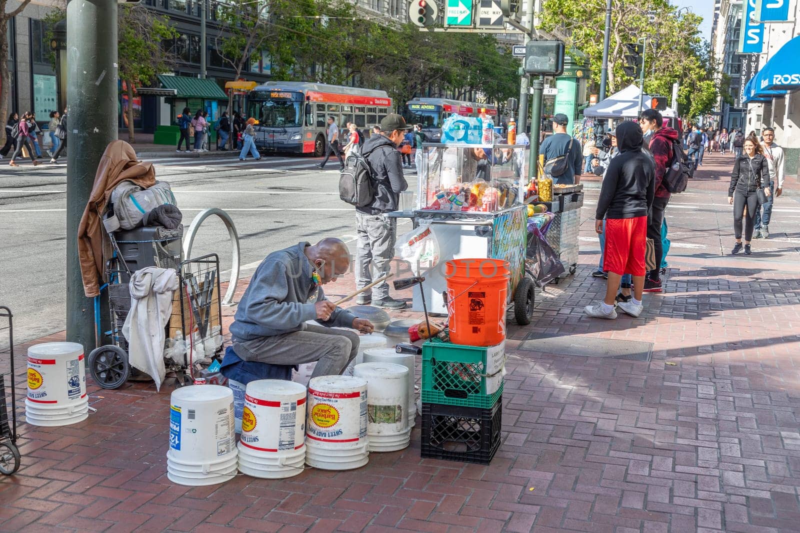 San Francisco, USA - May 20, 2022:  man playing drums made of plastic buckets at the street to earn some money.