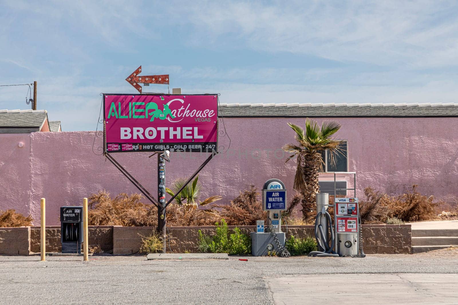 Pahrump, USA - May 23, 2022: Area 51 direction sign in Pahrump at the petrol station to the attached Brothel. Air and water service in background at the petrol station.