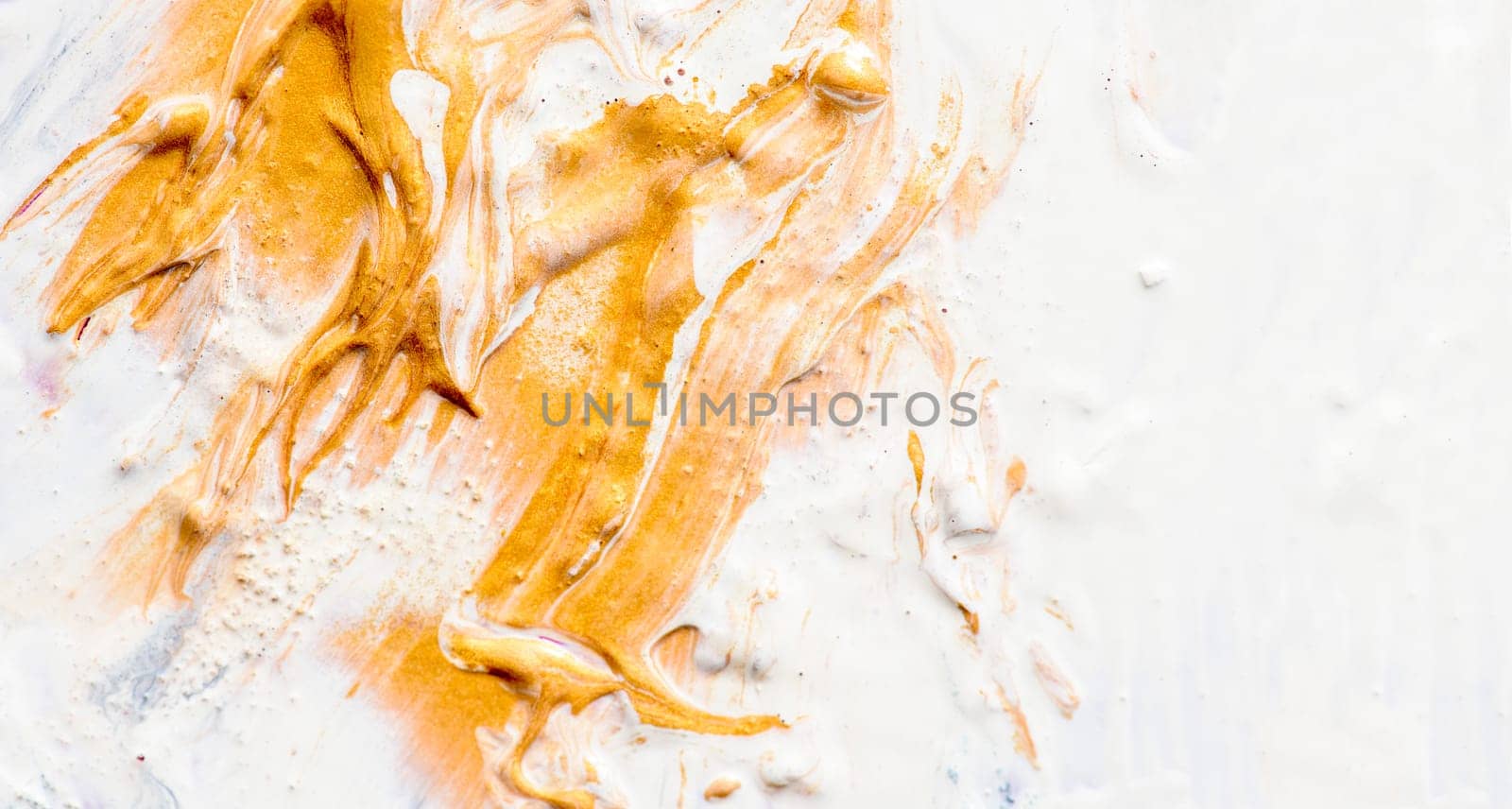 Golden and white oil paint on artist canvas. Fine art gold acrylic color closeup. Abstract creative background texture.