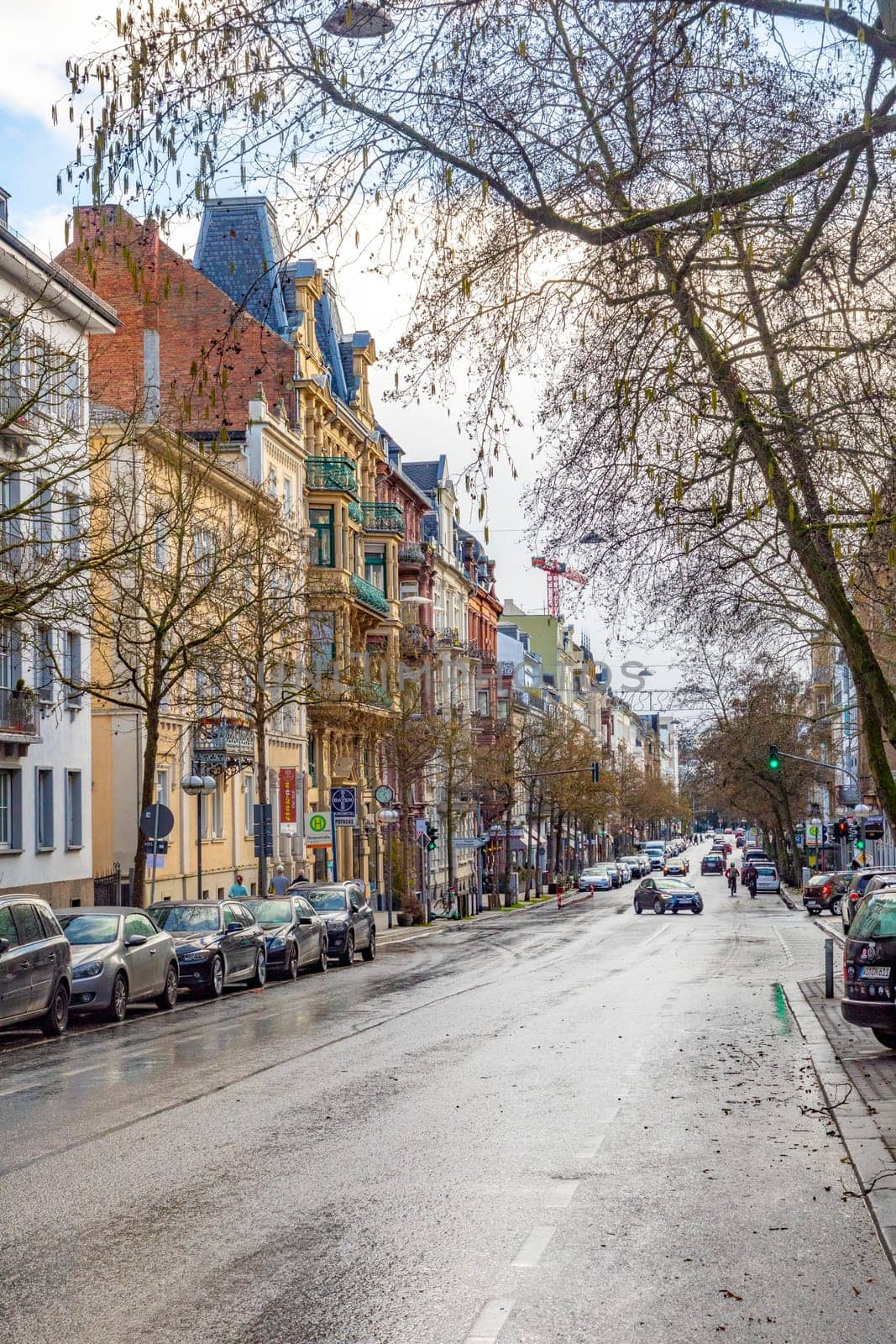 Wiesbaden, Germany - February 25, 2023: view to old street Taunusstrasse in Wiesbaden with historic buildings and wet road.