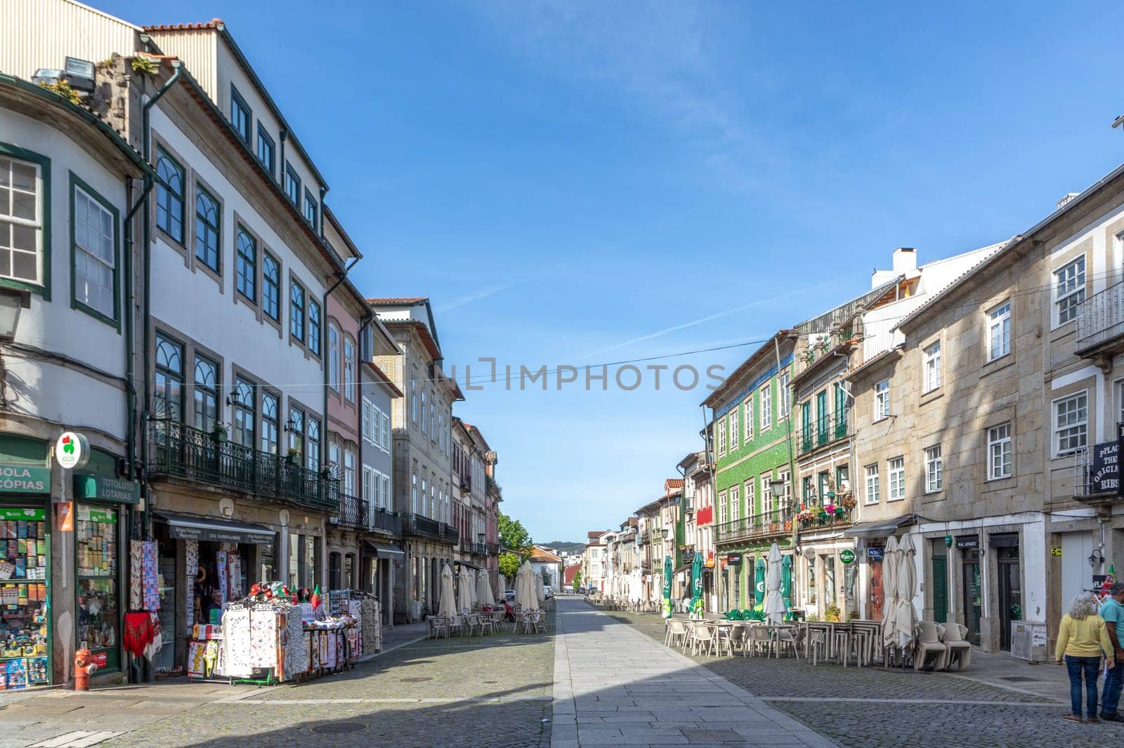 Braga, Portugal - May 1, 2023:street scene in the old town of Braga with historic facades and people in early morning.