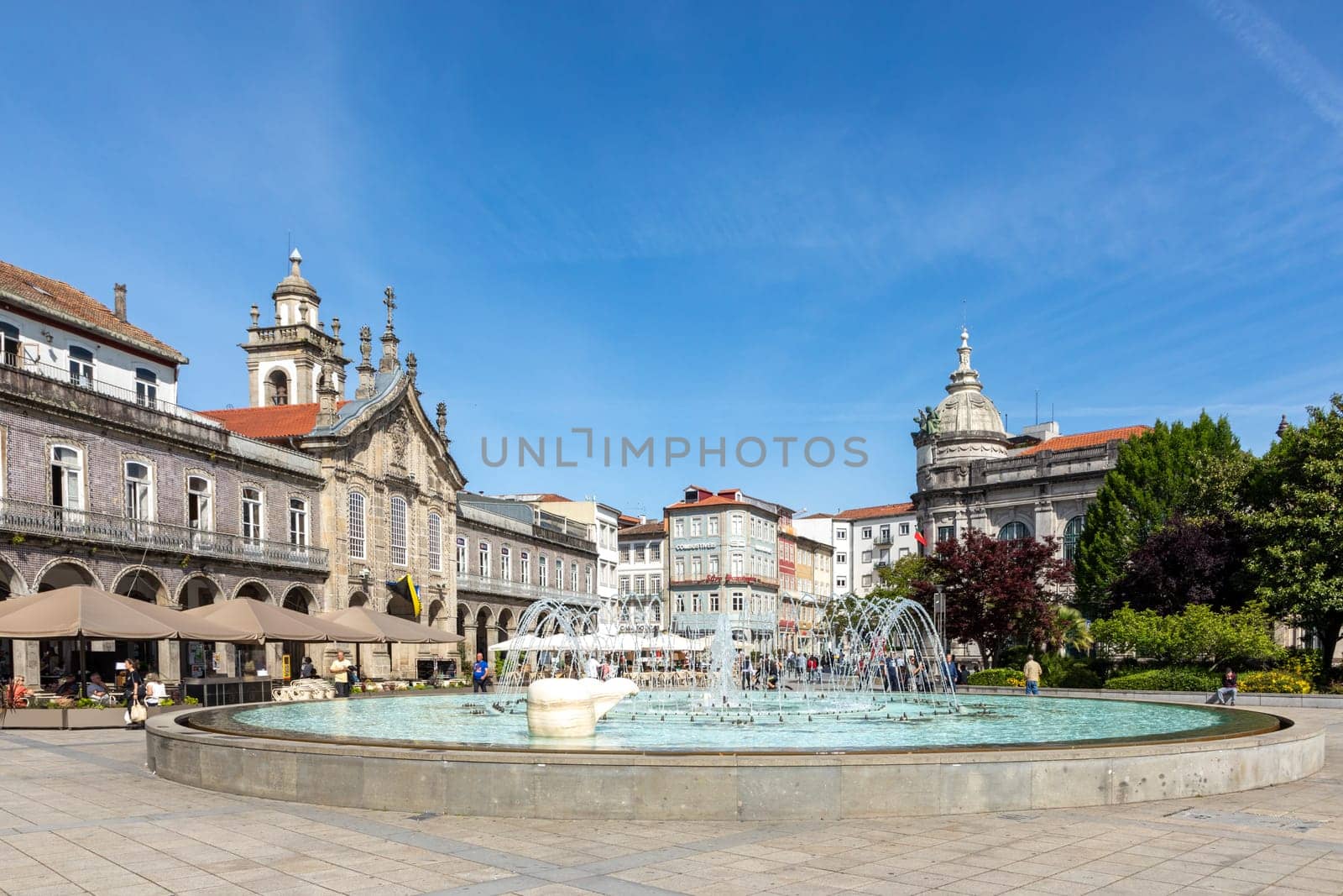 Braga, Portugal - May 1, 2023: sunrise view of Praca da Republica in the historical center of Braga, Portugal with reflection in fountain.