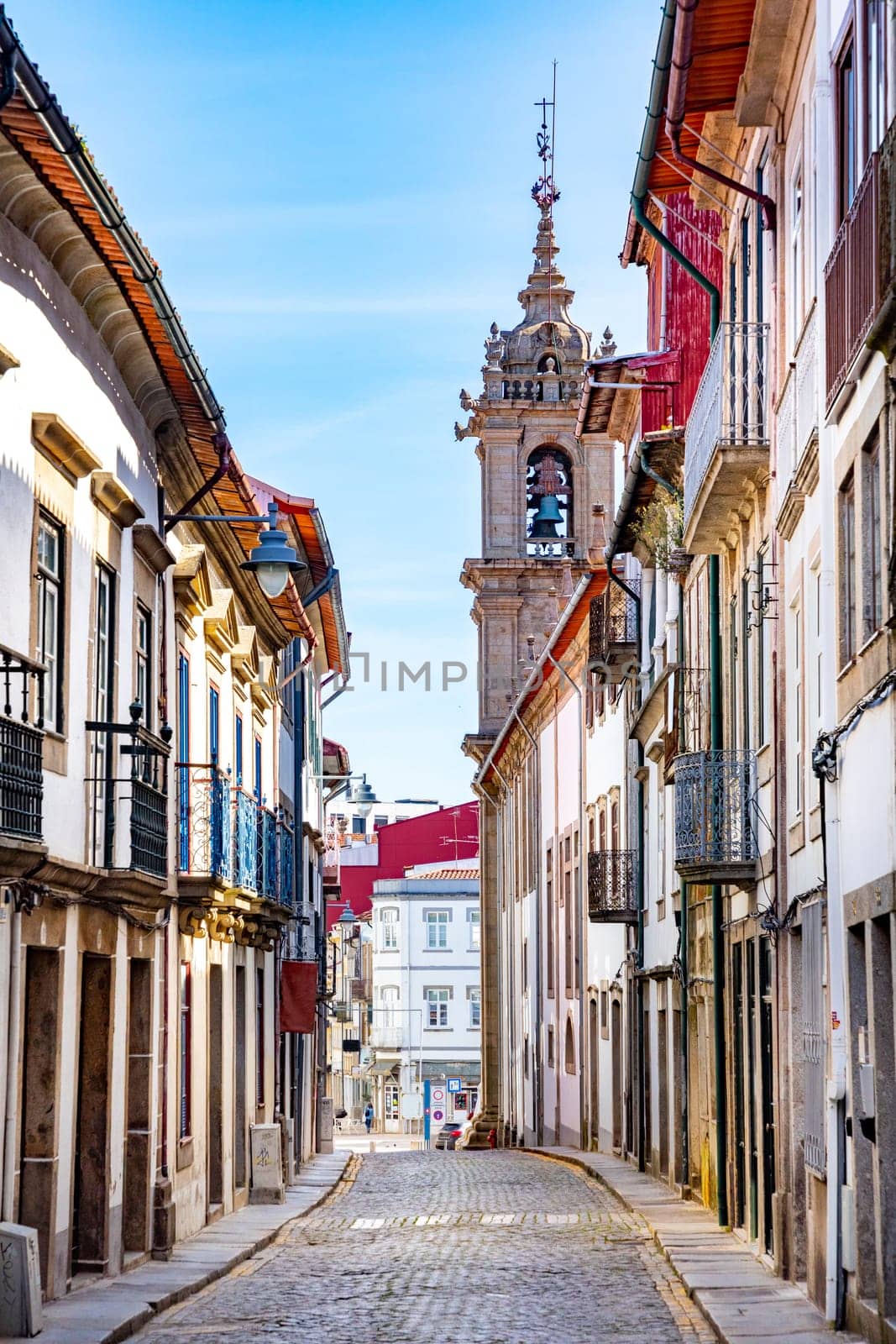 Braga, Portugal - May 1, 2023: street scene in the old town of Braga with historic facades and people in early morning.
