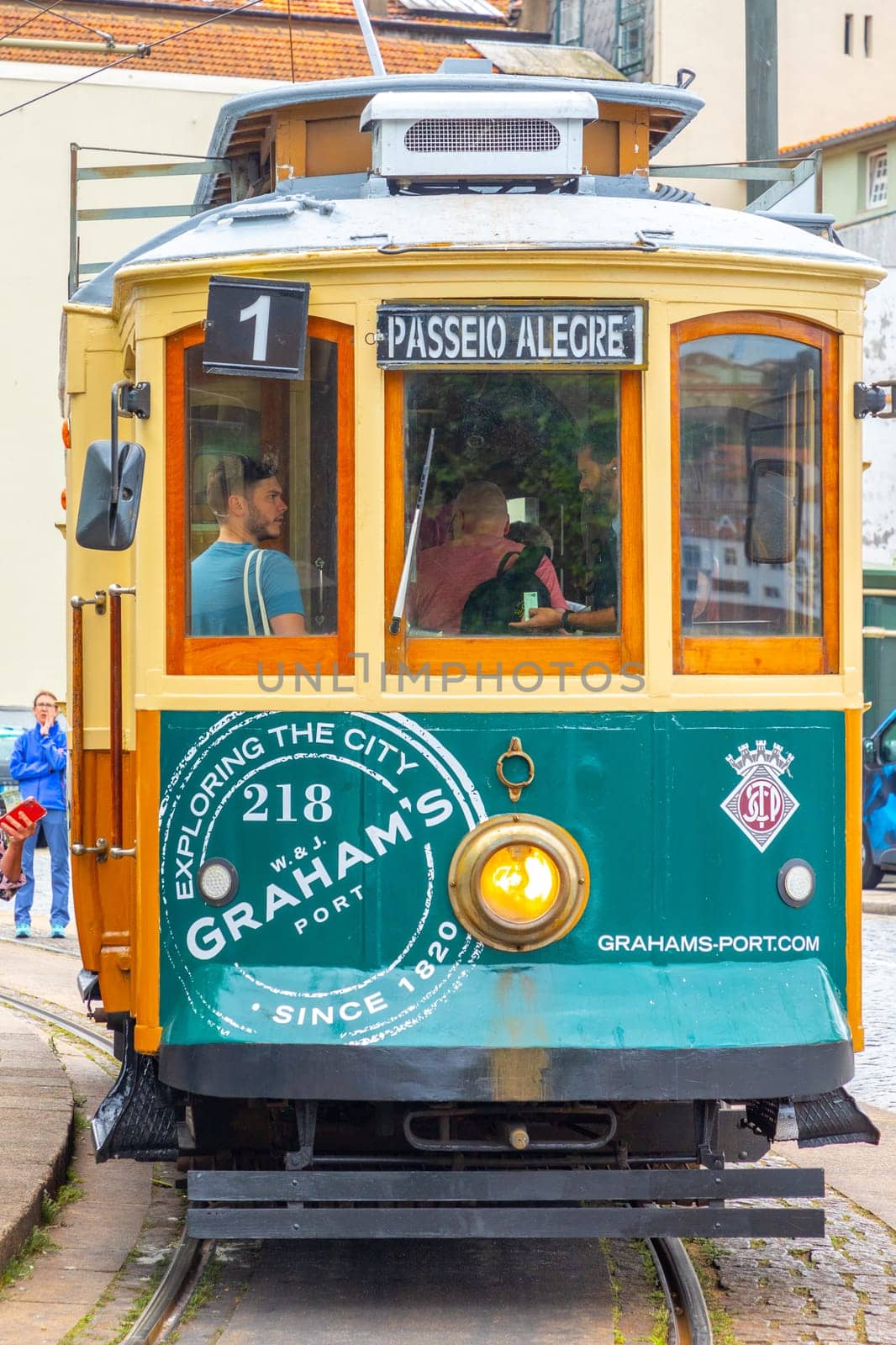 Porto, Portugal - May 4, 2023: Porto, vintage Portuguese traditional city tram Infante 1 designed with advertisements with the view on the river