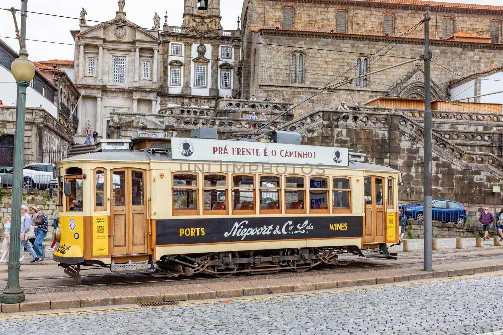 Porto, Portugal - May 4, 2023: Porto, vintage Portuguese traditional city tram Infante 1 designed with advertisements with the view on the river