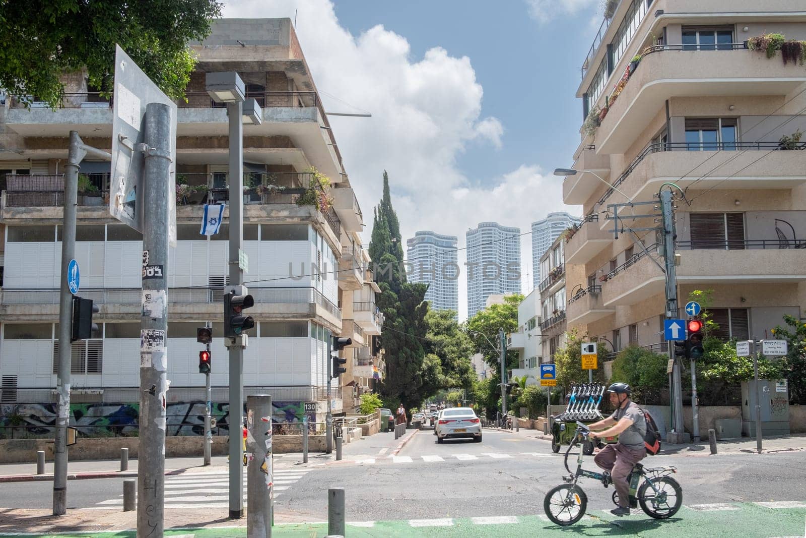Tel Aviv, Israel - May 18, 2023: view from Rothschild Boulevard with bycicle rider to houses built in Bauhaus style, imported from german architects.