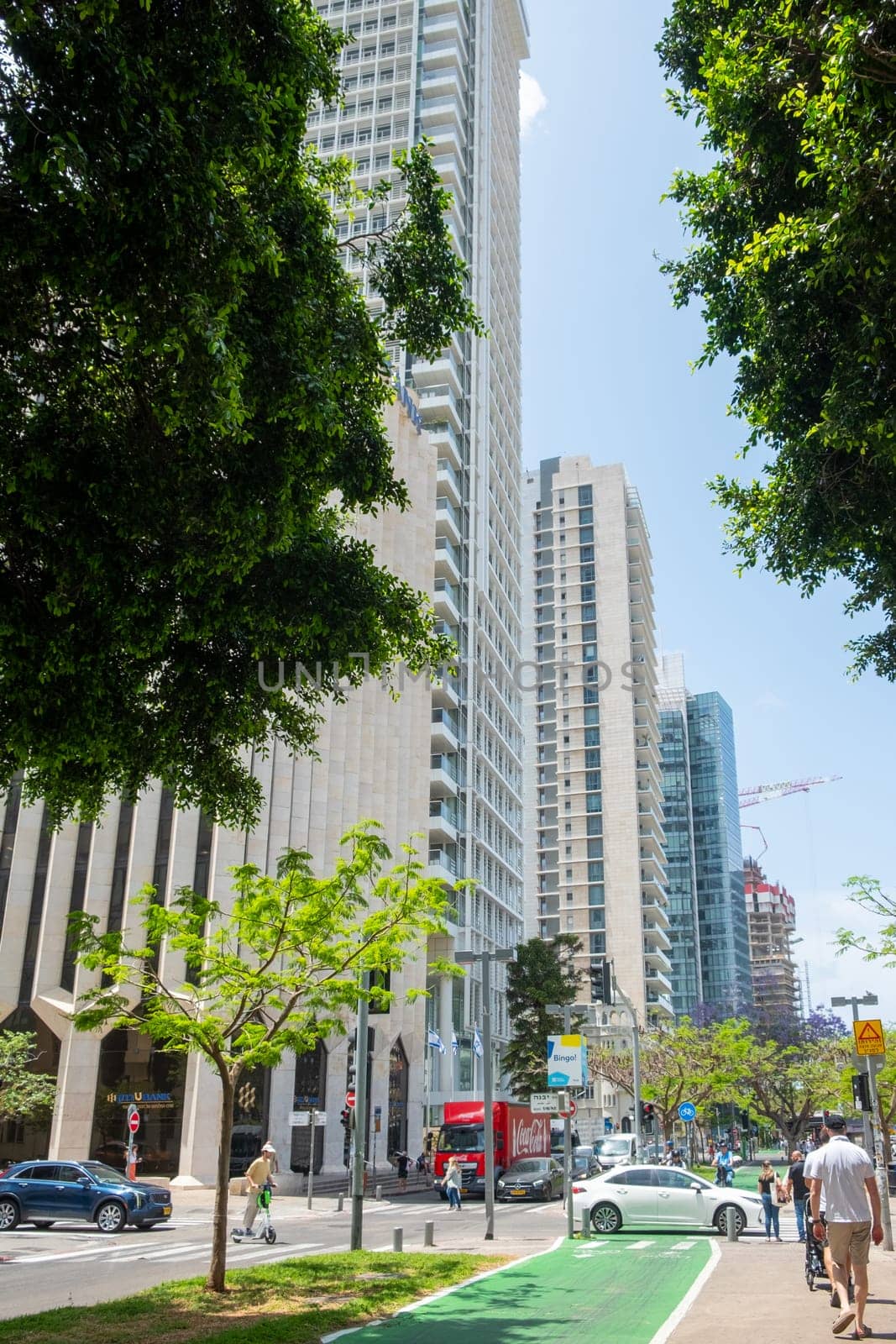 Tel Aviv, Israel - May 18, 2023: View of modern skyscrapers in the city center of Tel Aviv, Israel, at the crossroads between Sderot Rothschild and Yavne Street with street scenes.