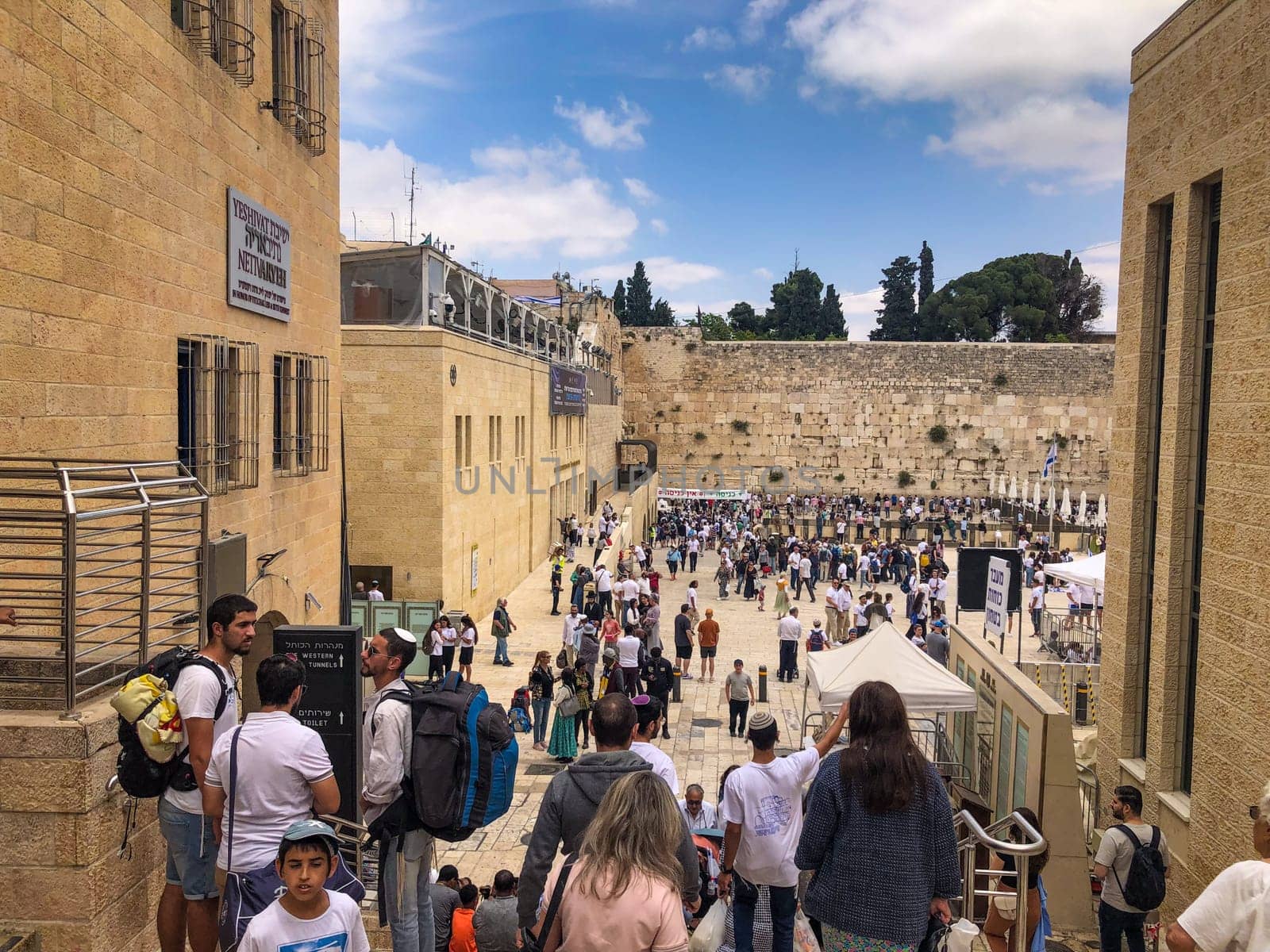 Jerusalem, Israel - May 19, 2023: people visit the most famous western wall at the old temple in Jerusalem. They pray at the wailing wall and put written foulded papers into the wall.