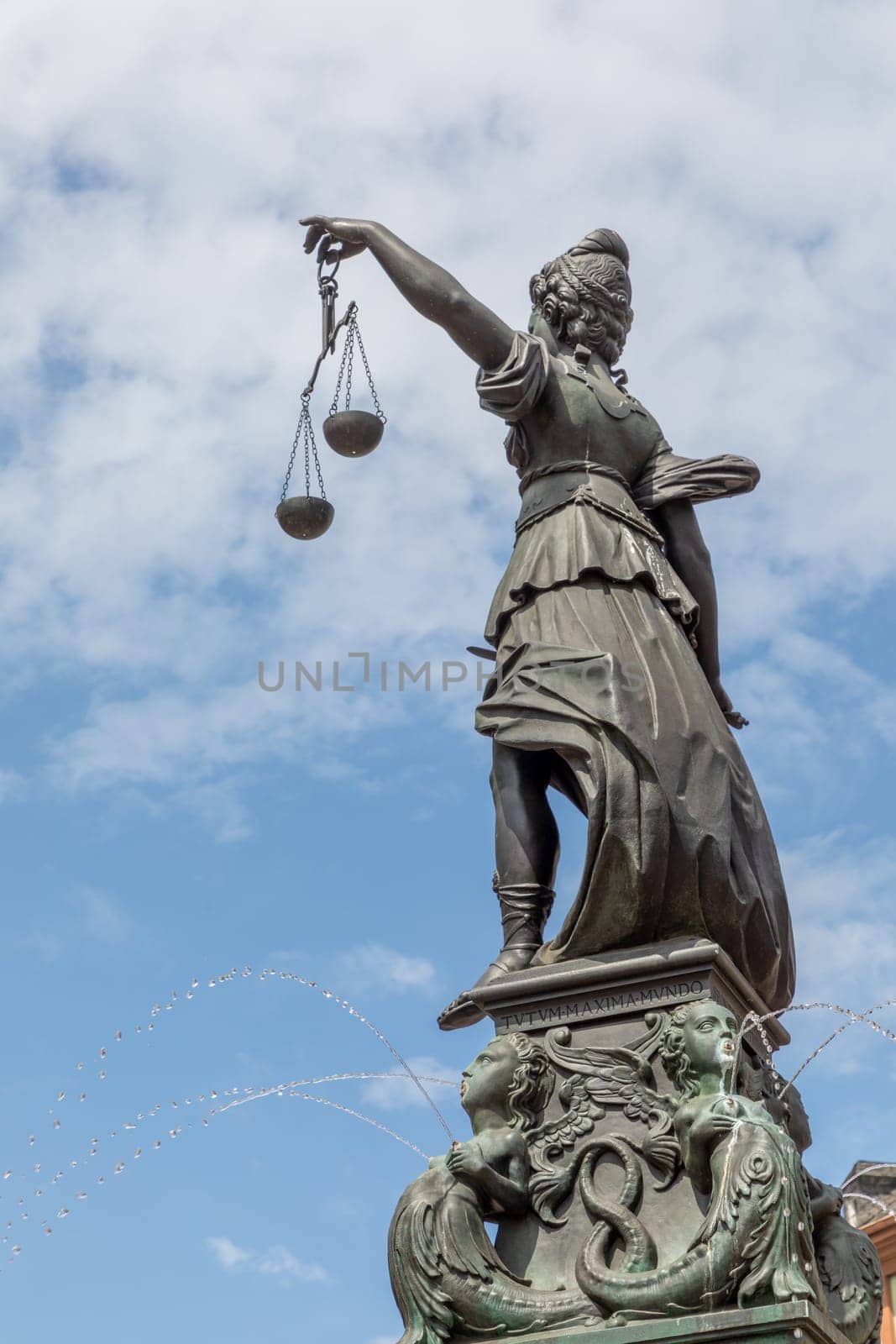 Frankfurt, Germany - May 24, 2023: lady justice in Frankfurt with sword and cloudy sky as symbol for justice and law