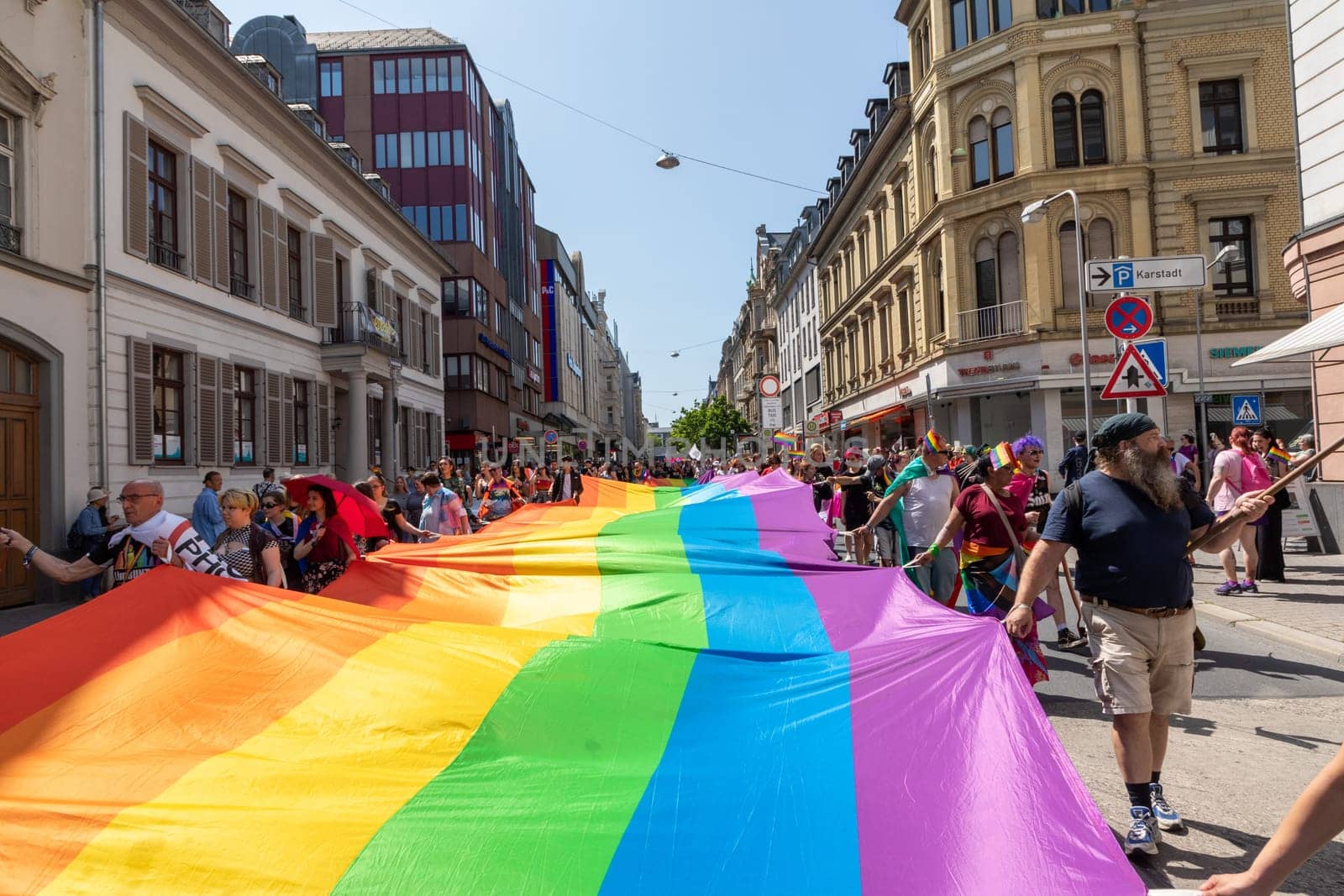 Wiesbaden, Germany - May 27, 2023: people enjoy the christopher street parade in Wiesbaden with rainbow flags and beaufiful costumes.
