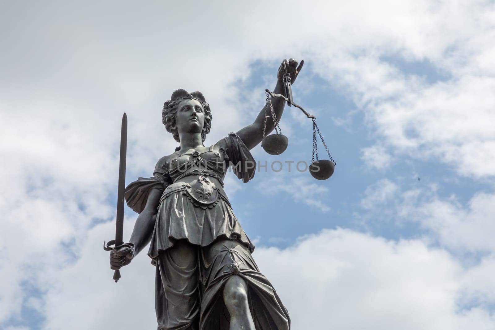 Frankfurt, Germany - May 24, 2023: lady justice in Frankfurt with sword and cloudy sky as symbol for justice and law