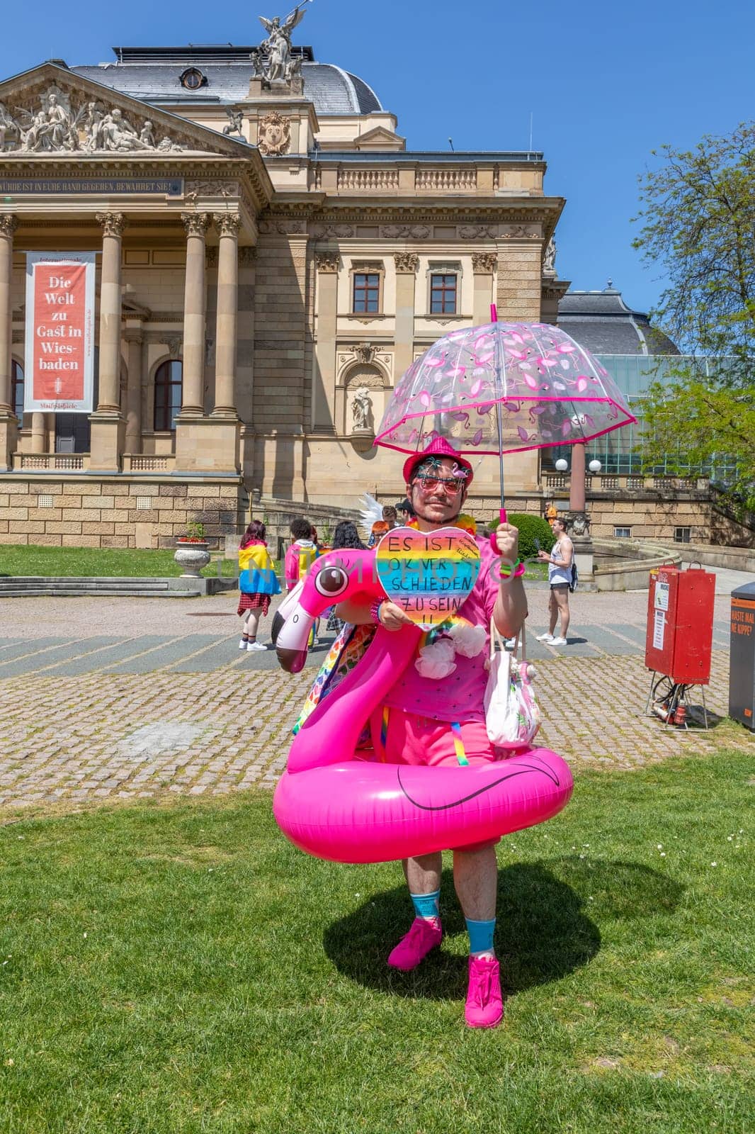 Wiesbaden, Germany - May 27, 2023: people enjoy the christopher street parade in Wiesbaden with rainbow flags and beaufiful costumes.