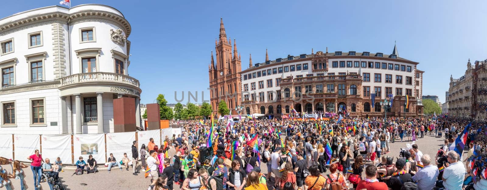 Wiesbaden, Germany - May 27, 2023: people enjoy the christopher street parade in Wiesbaden with rainbow flags and beaufiful costumes.