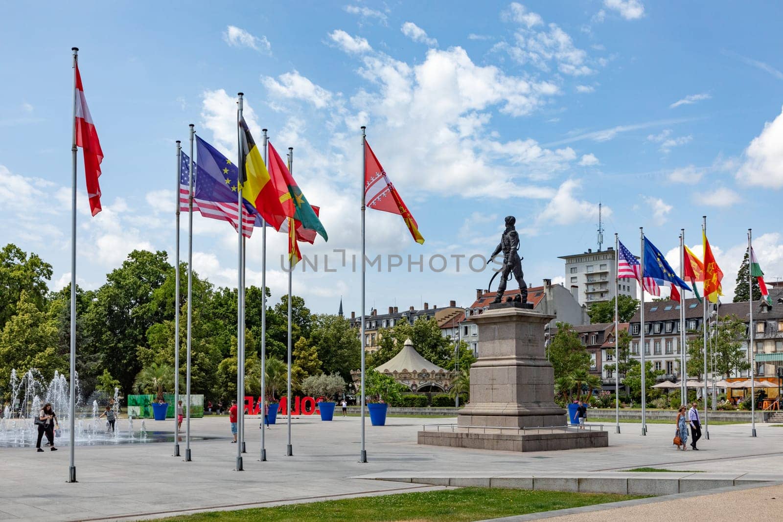Colmar, France - June 21, 2023: statue of General Rapp at Rapp square with flags of the contries of the european union in Colmar, France