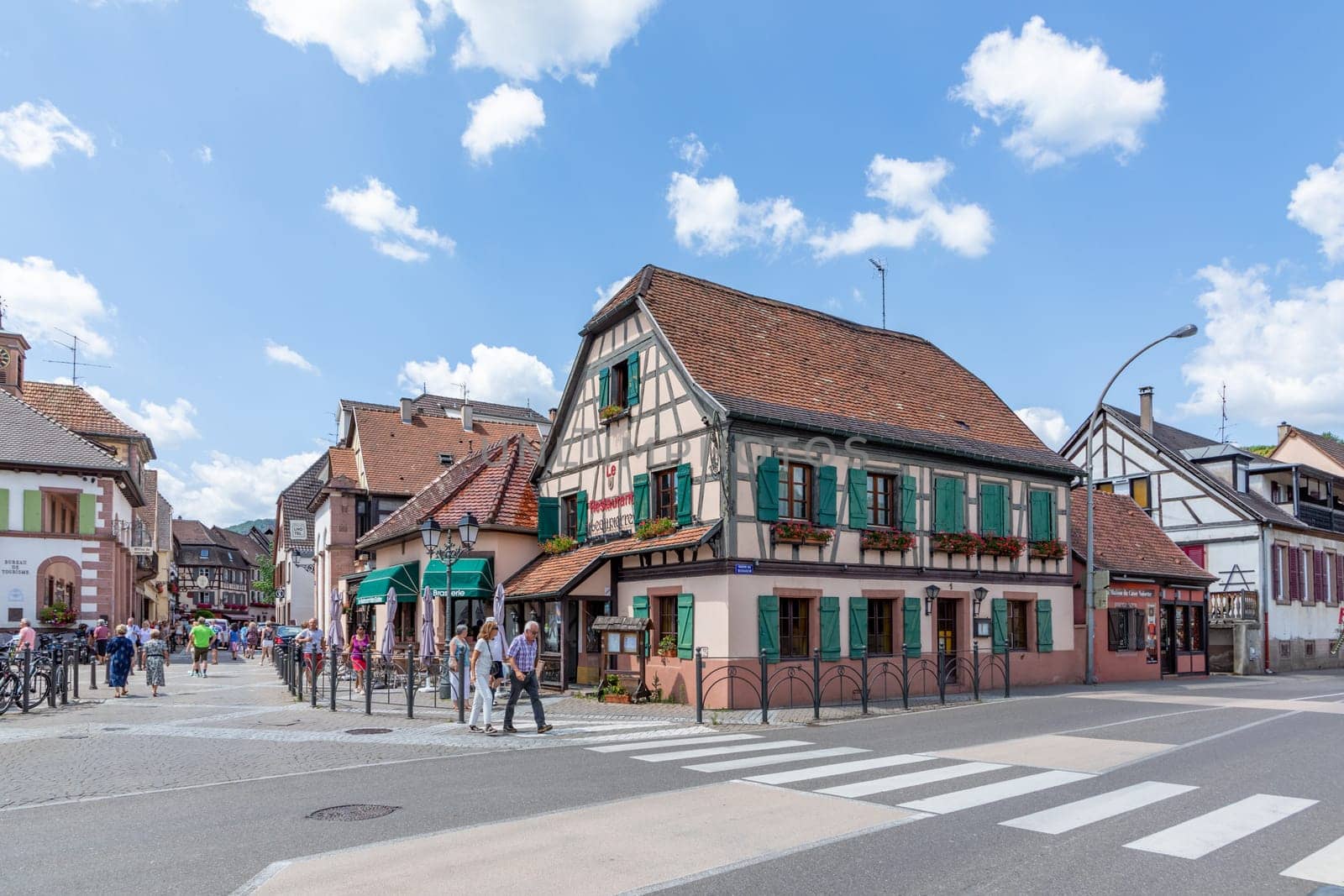 Ribeauville, France - June 23, 2023: A picturesque colorful street of half-timber buildings with shops and cafes in the village of Ribeauville, in the Alsace region.