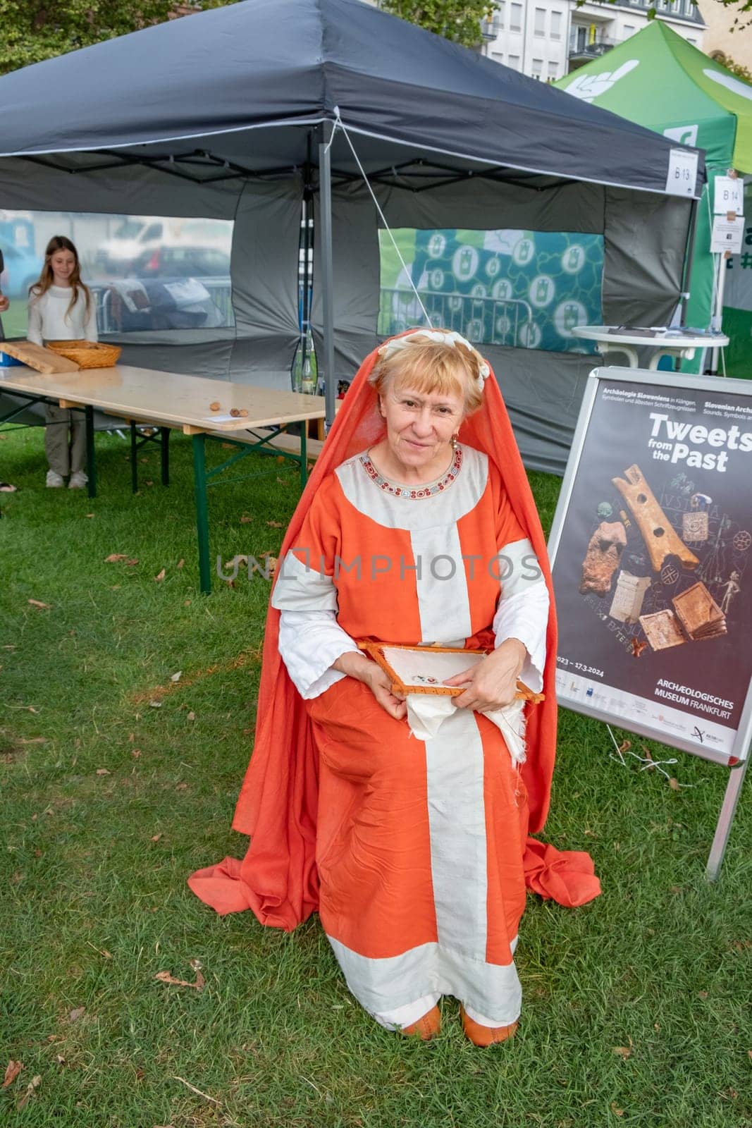 Frankfurt, Germany - August 26, 2023: woman in medieval costumes at the Museumsuferfest - engl: festival of the Museums at the river - shows her embroidery.