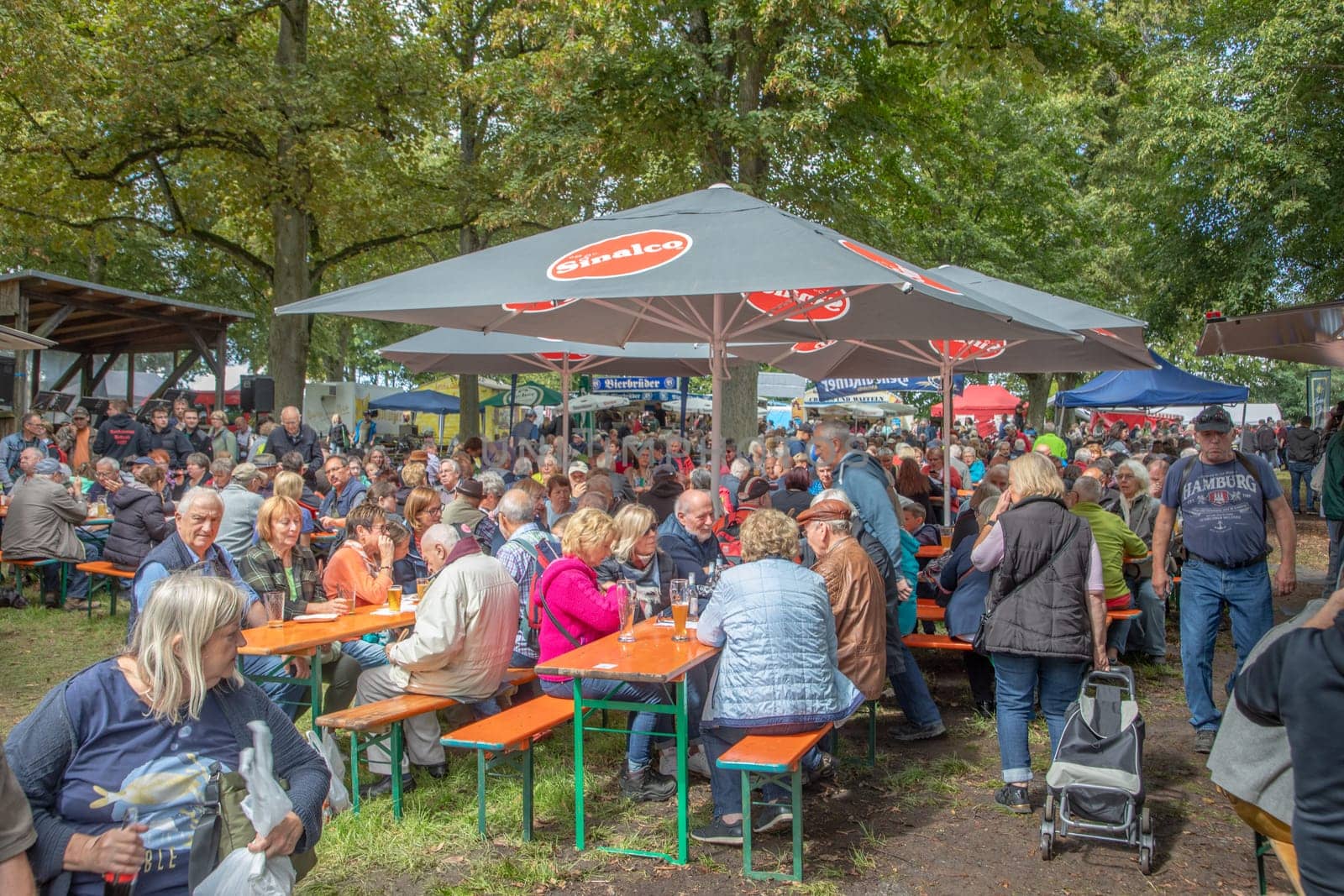 Idstein, Germany - August 31, 2023: peope enjoy resting under the shadow of trees at Alteburger market in Idstein, Germany.