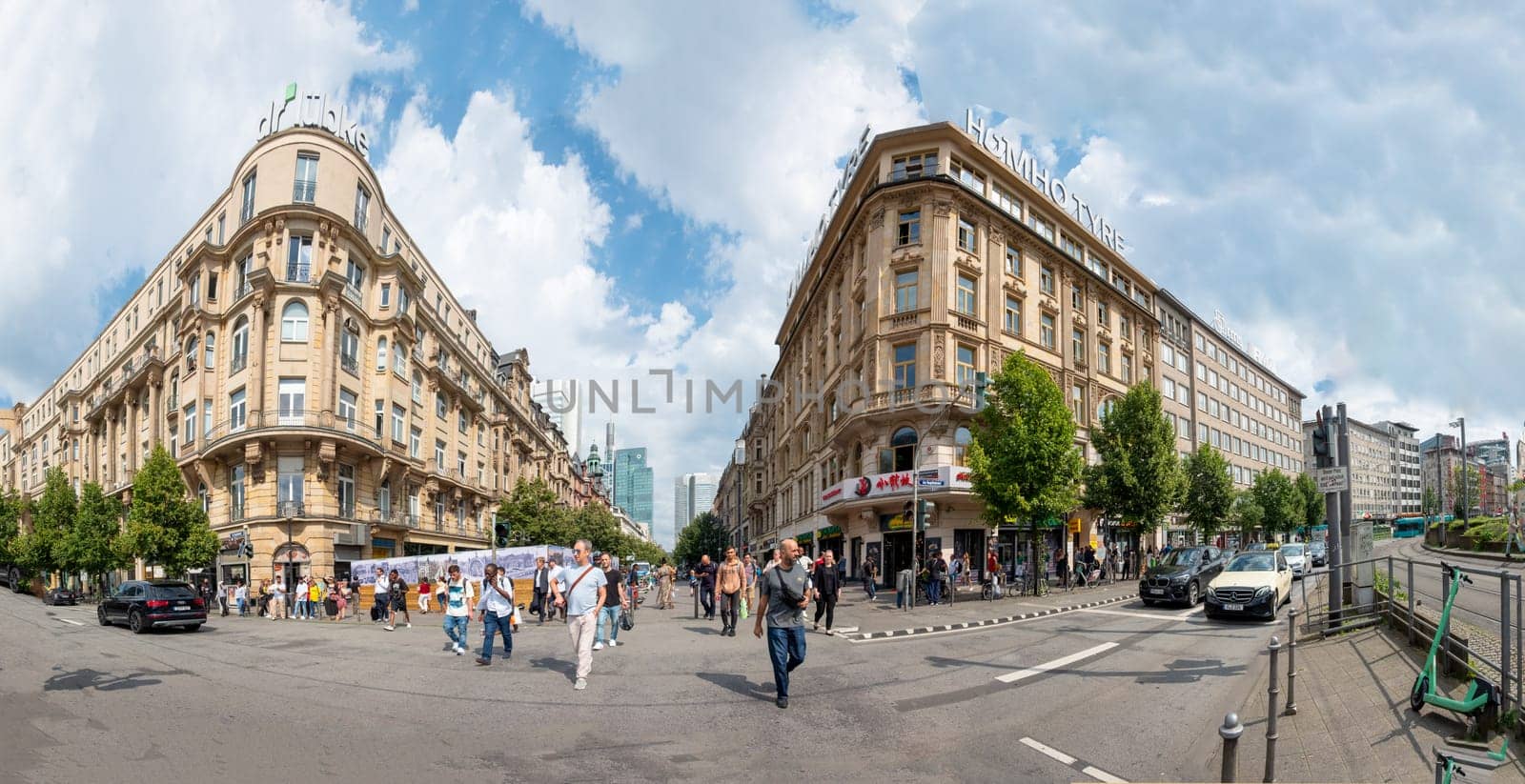 Frankfurt, Germany - August 16, 2023: people at the foreground of the central train station in Frankfurt and view to historic wilhelmenian buildings at train station area.