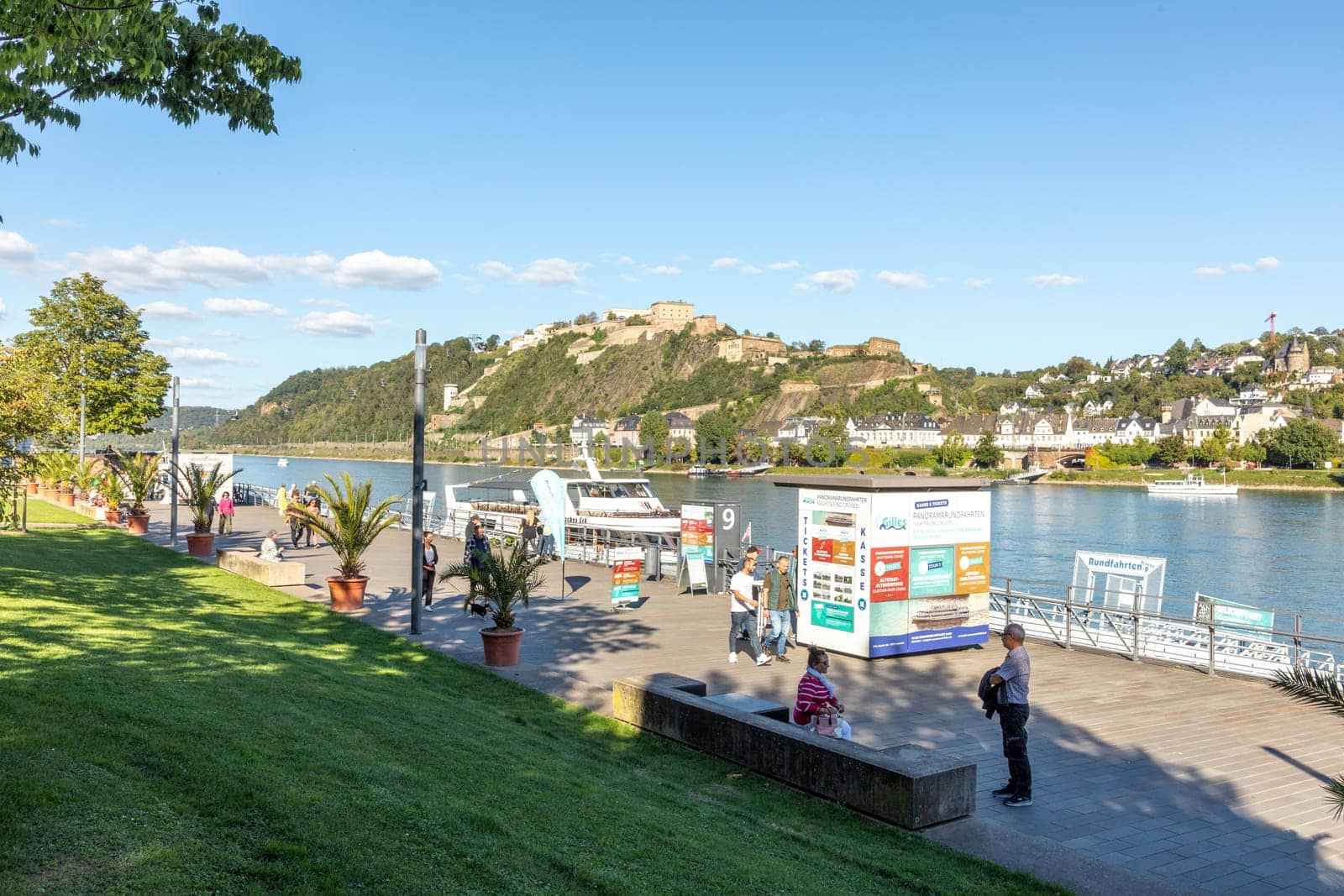 Koblenz, Germany - September 24, 2023: people promenade at river Rhine with view to historic fortress Ehrenbreitstein in Koblenz.