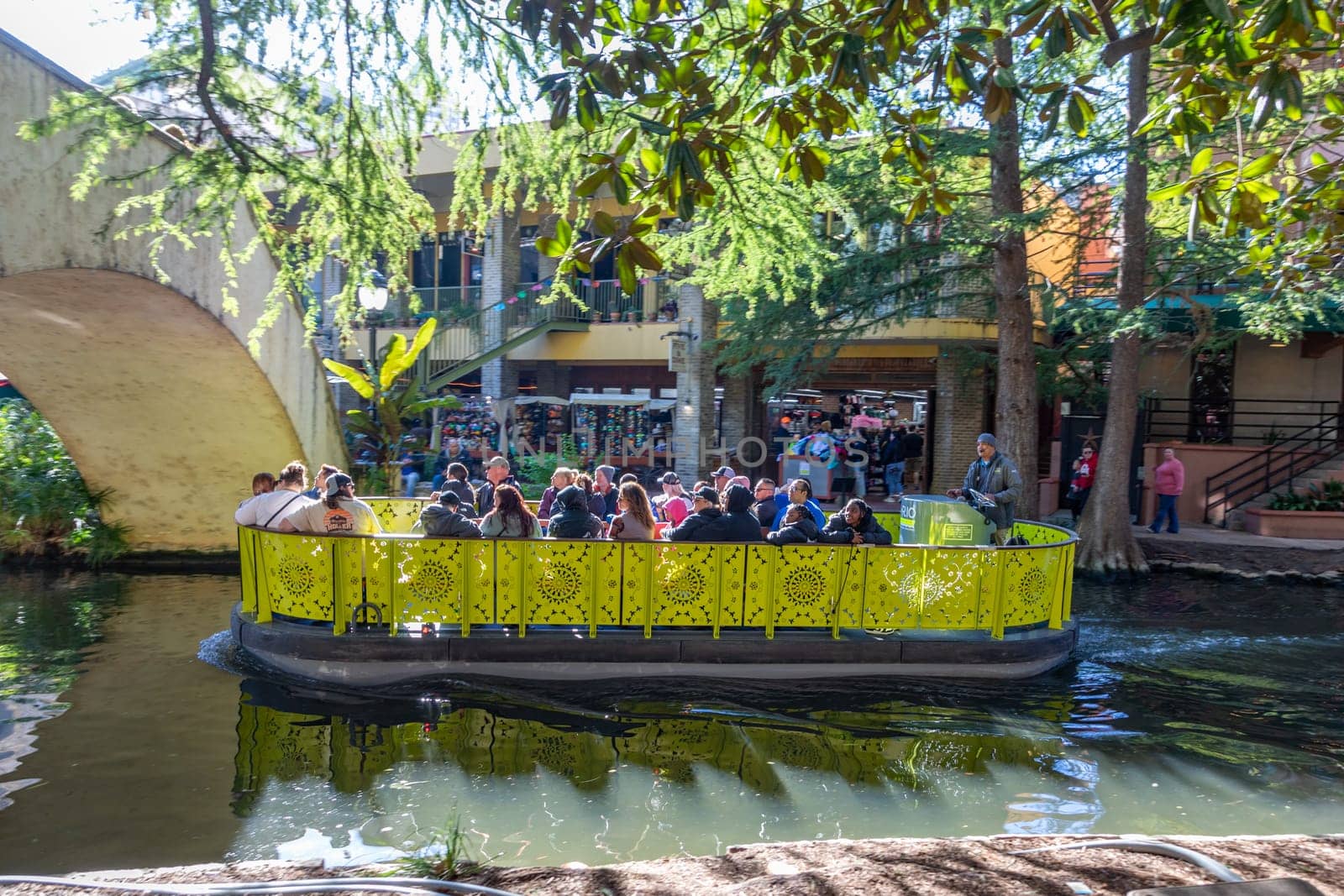 San Antonio, USA - October 31, 2023:  people enjoy the boat trip at  San Antonio River Walk. City park and pedestrian street in San Antonio, Texas. USA