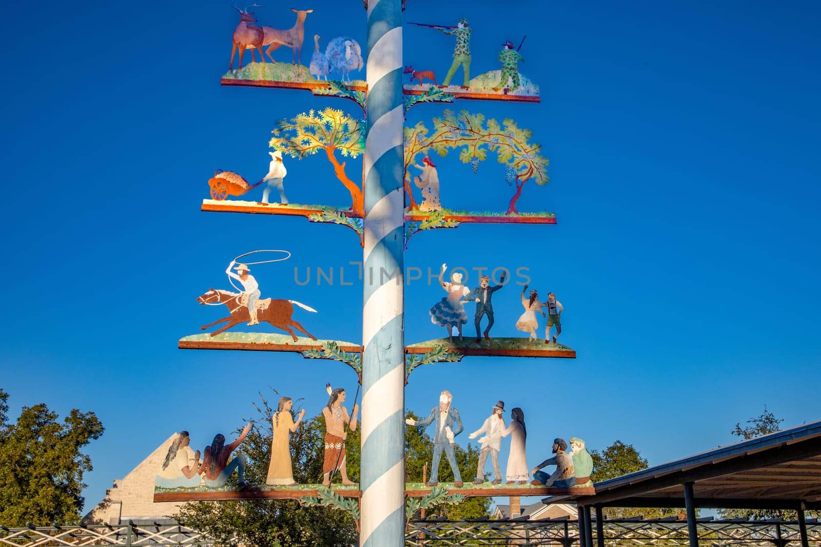 Fredericksburg, USA - November 1, 2023: maypole at market square in Fredericksburg, following the bavarian tradition with cowboys, indians, dancer, hunter and all the american former roles in the wild west, Texas, USA.