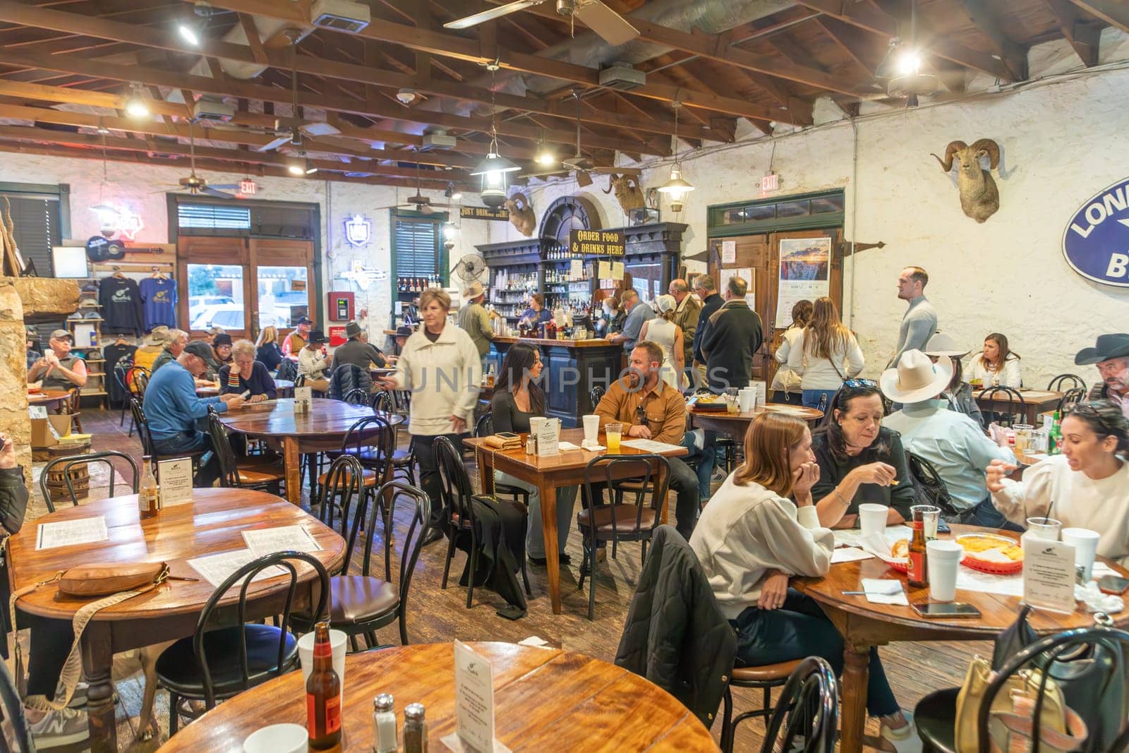Fredericksburg, USA - November 1, 2023: people enjoy the western music performance in a food and bar saloon in Frederiksburg, Texas.