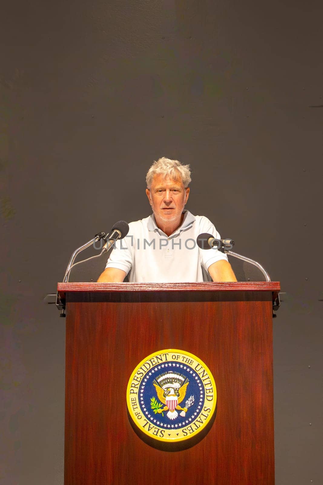 Dallas, USA - November 7, 2023: tourist at the lectern of John F. Kennedy with the seal of the president of the USA in the sixth floor museum in Dallas.