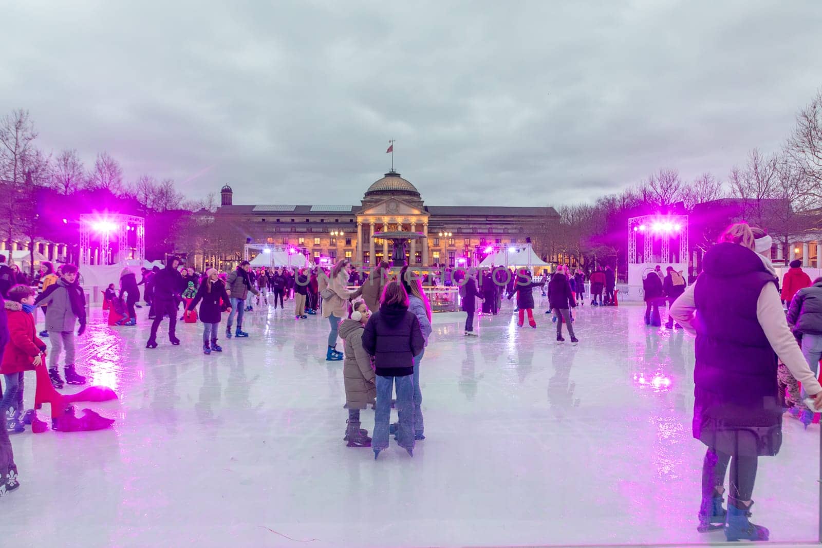 Wiesbaden, Germany - December 29, 2023: people enjoy the rink in front of the kurhaus in Wiesbaden, Hesse, germany.