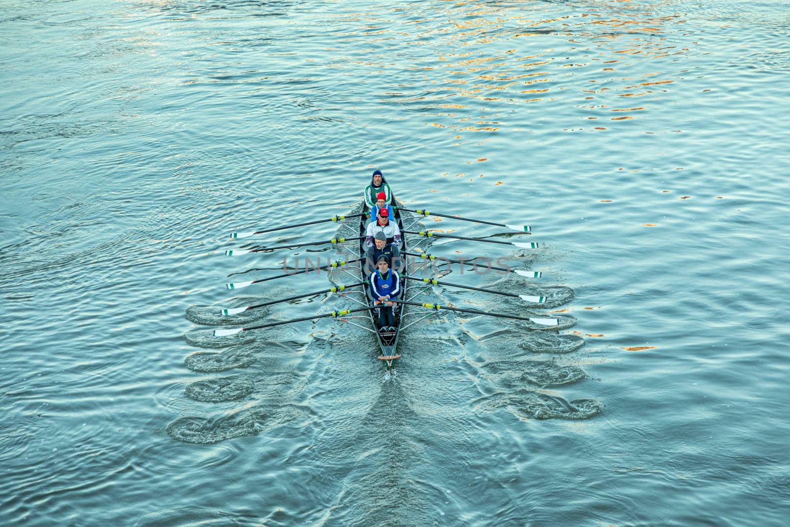 aerial of rower in early morning at the river in an five people boat