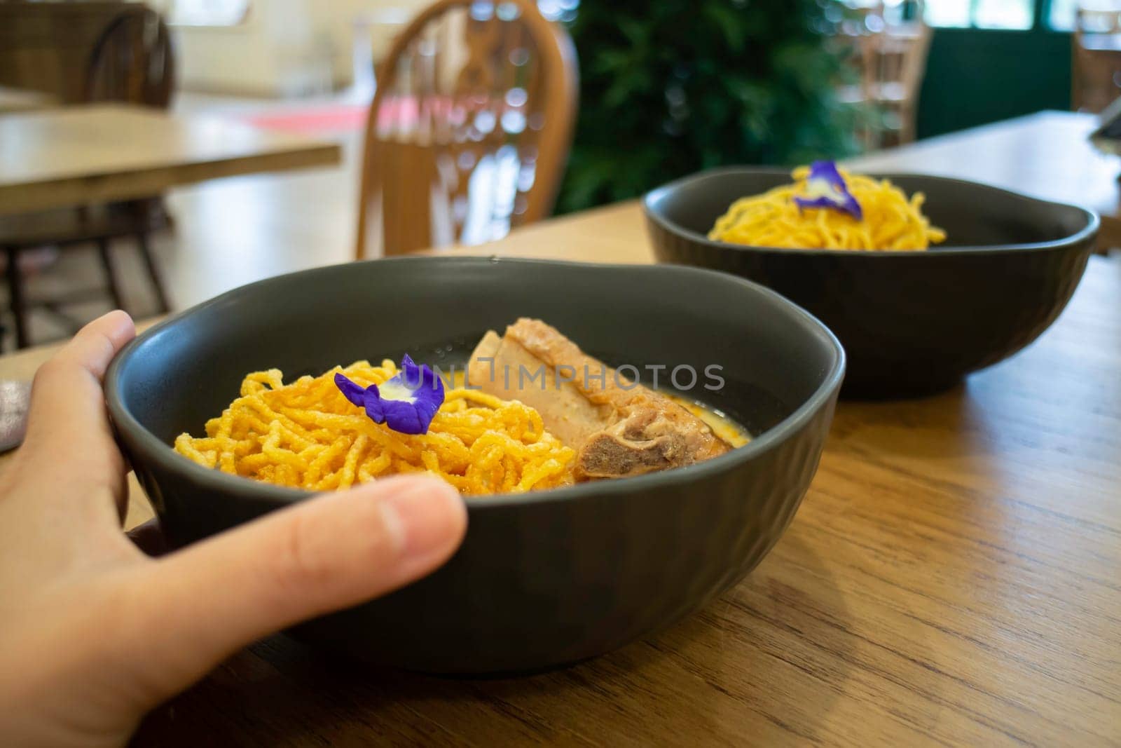 Thai noodles Khao Soi, spicy curry with seasoning on table, stock photo