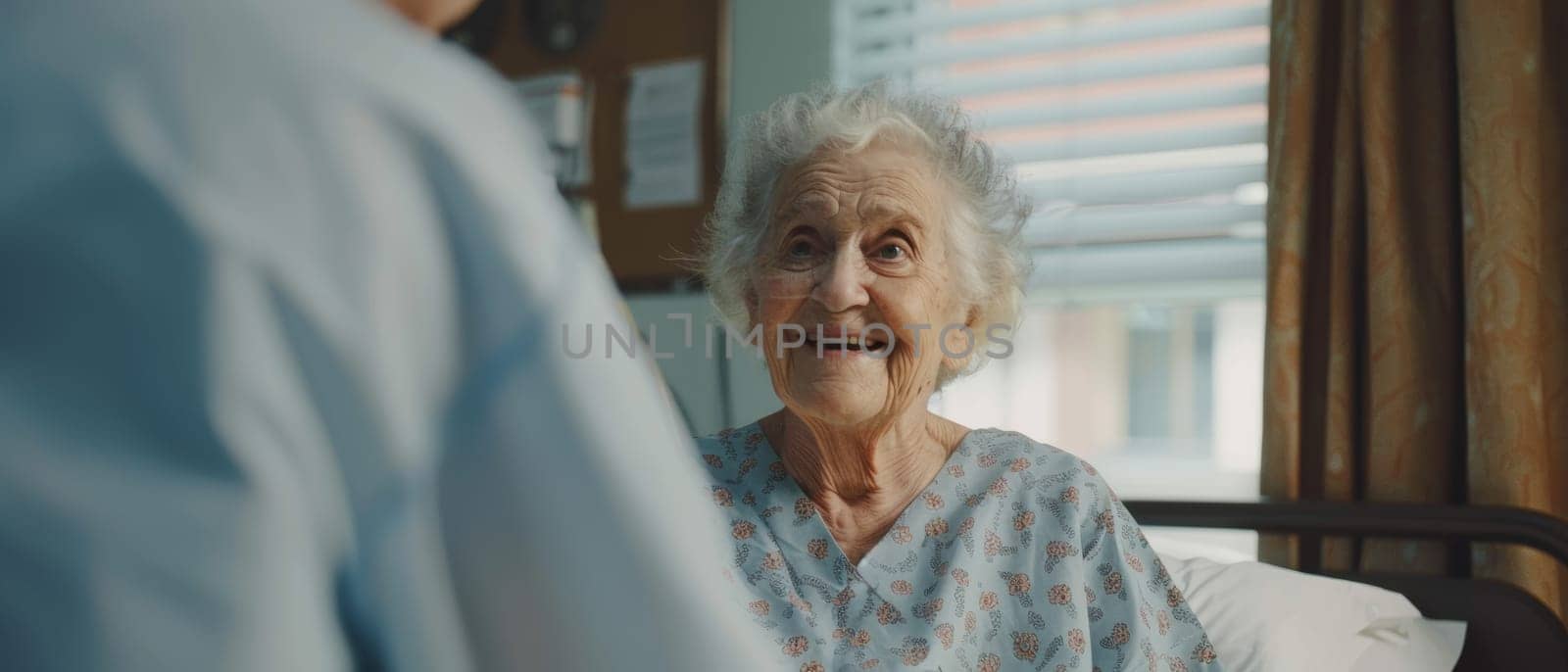A senior woman's warm smile fills the hospital room as she chats with a caregiver, her spirit undiminished by her surroundings