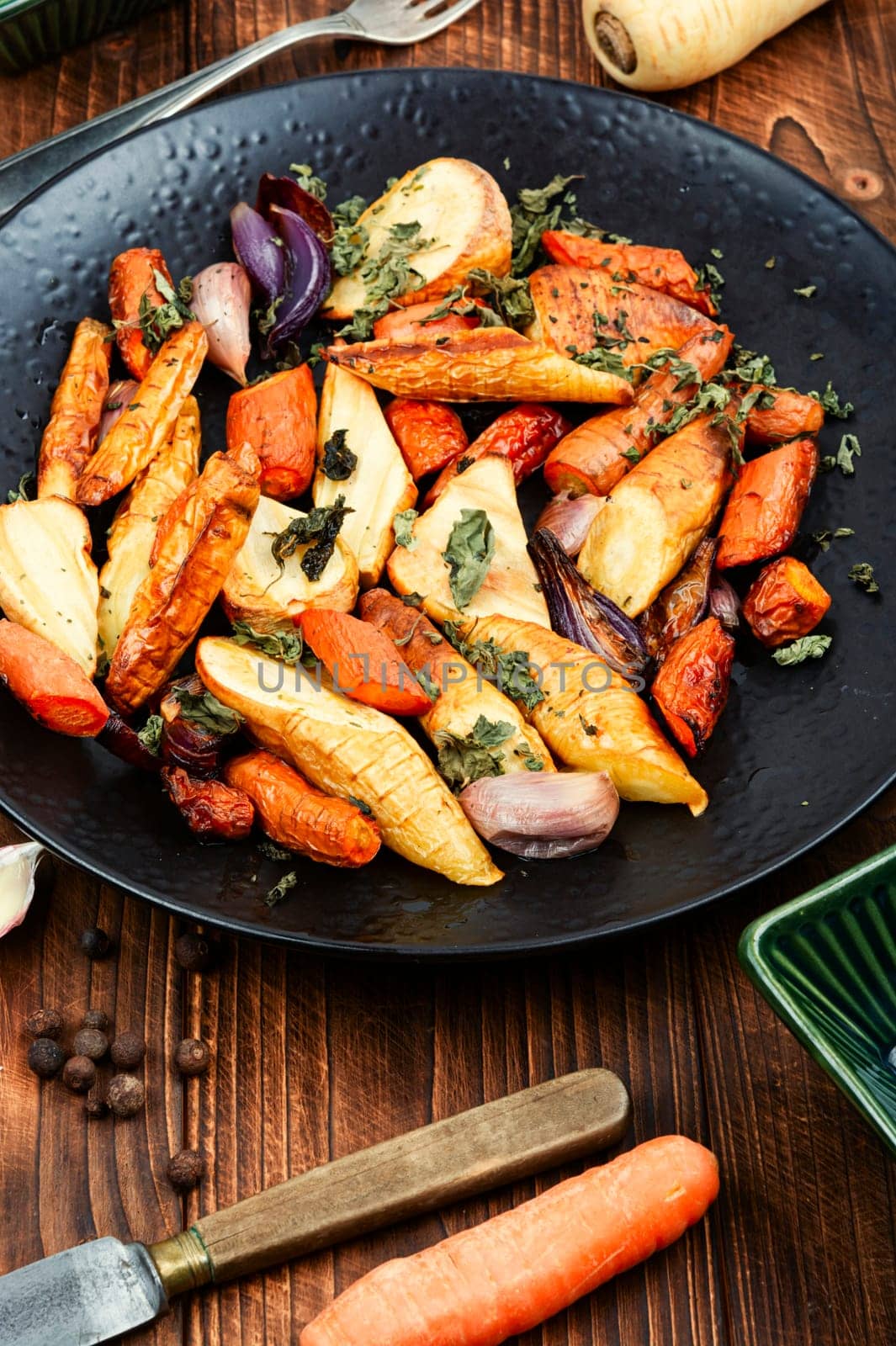 Healthy homemade roasted parsnip root, carrots and garlic with herbs.