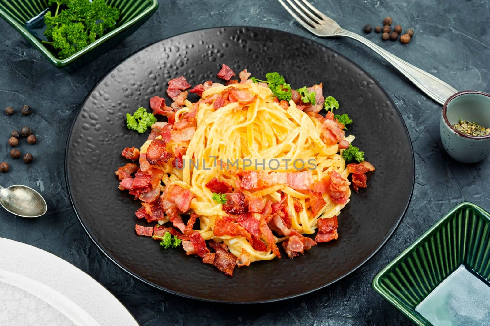 Pasta or spaghetti carbonara with bacon and parmesan on a plate. Close up.