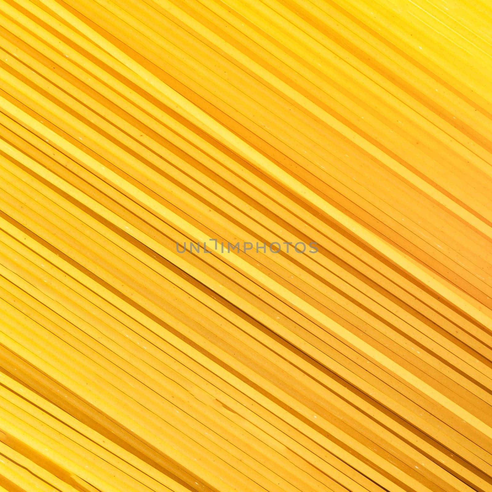 Background Spaghetti Pasta. Thin pasta arranged in rows. Yellow Italian pasta. Long spaghetti. Raw spaghetti wallpaper. Thin spaghetti. Food concept.