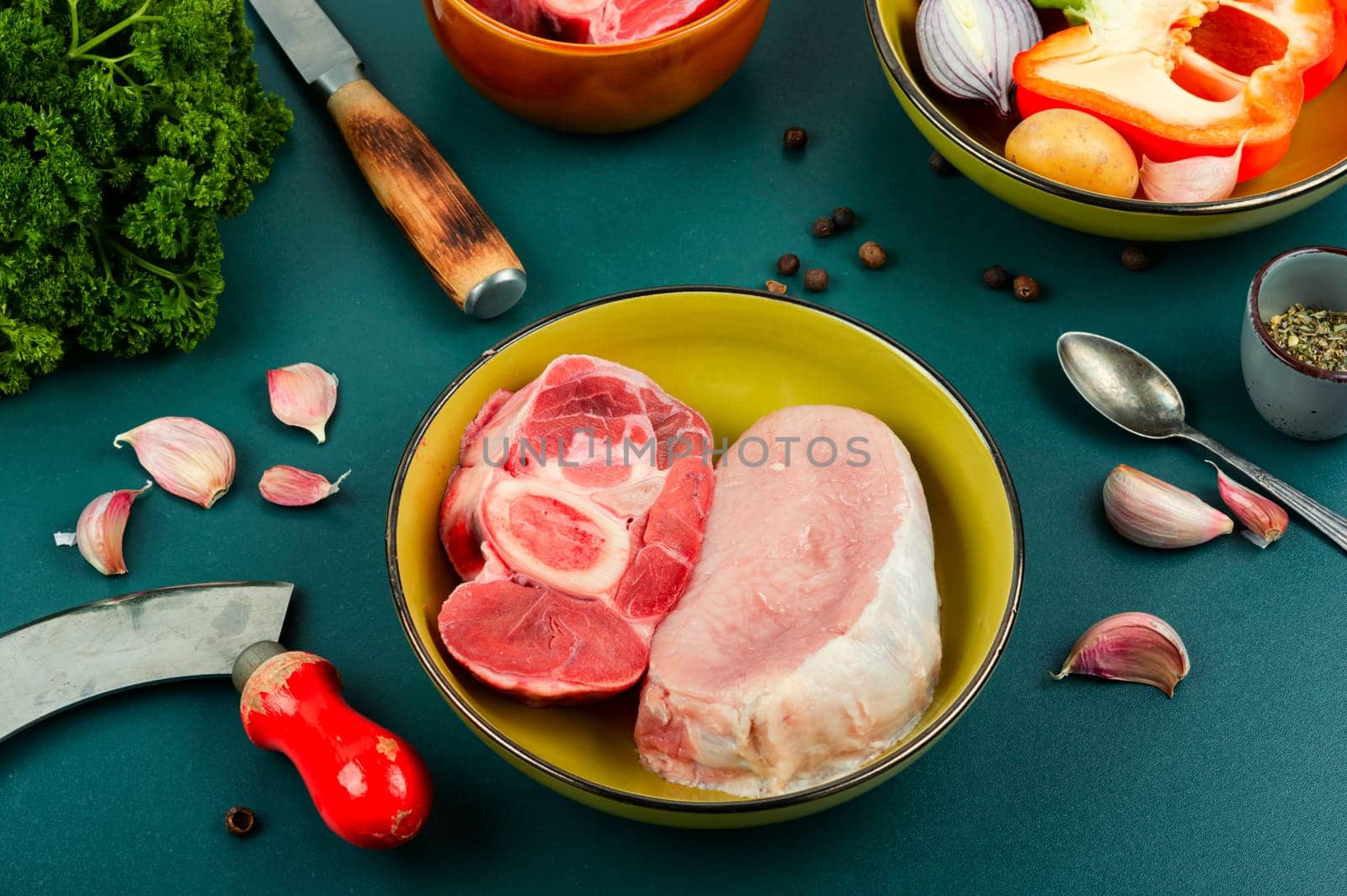 Juicy raw piece meat and vegetables on rustic wooden table. Set of ingredients for soup or borscht.