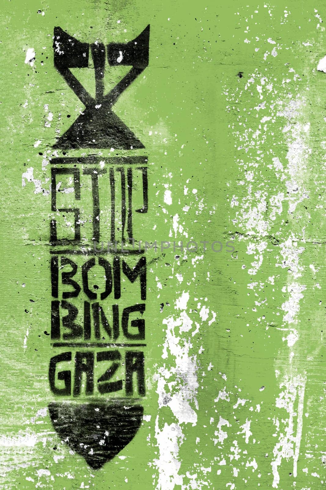 Graffiti on the green grungy wall depicting the silhouette of a bomb. Inside message: STOP BOMBING GAZA. Copy space. Fully editable.