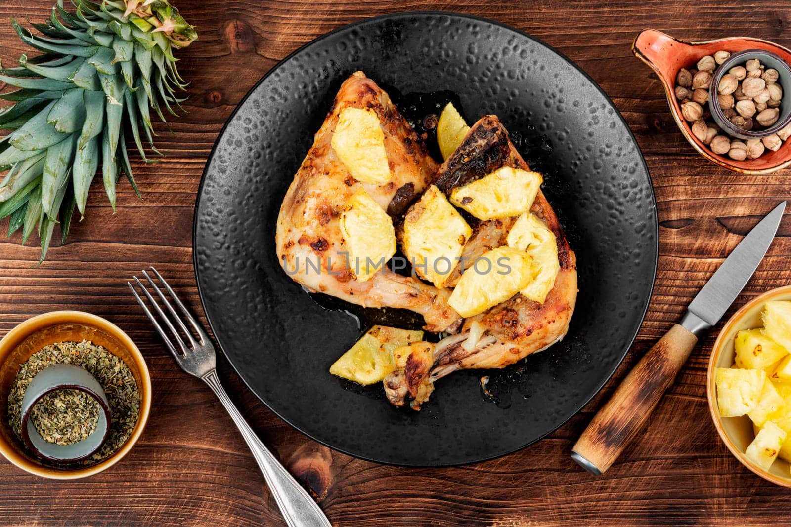 Chicken legs fried with pineapple pieces. Grilled chicken, grilled chicken legs on old wooden table.