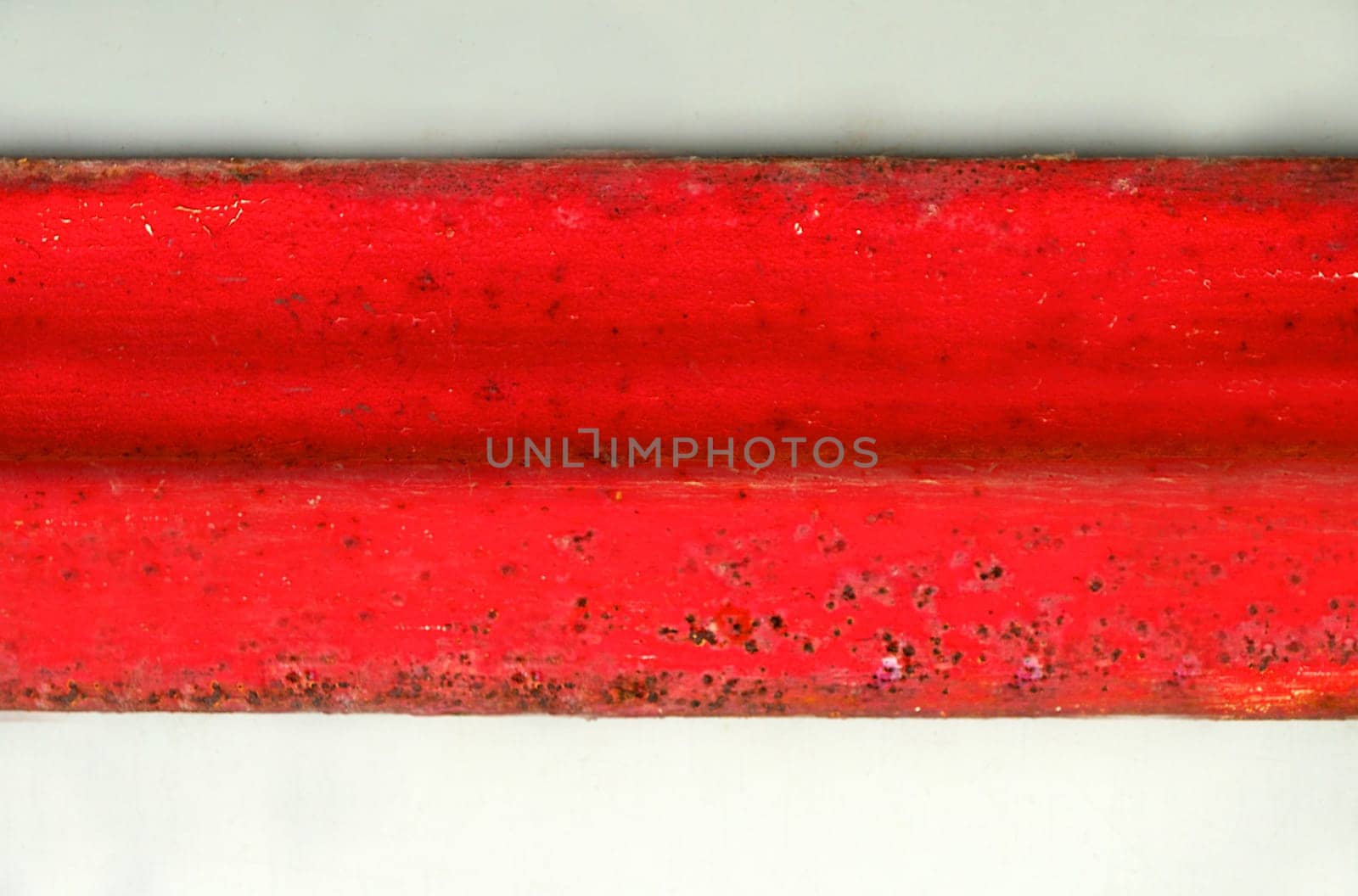Background texture of a red horizontal rusty wide metal plate on a light background close-up from above