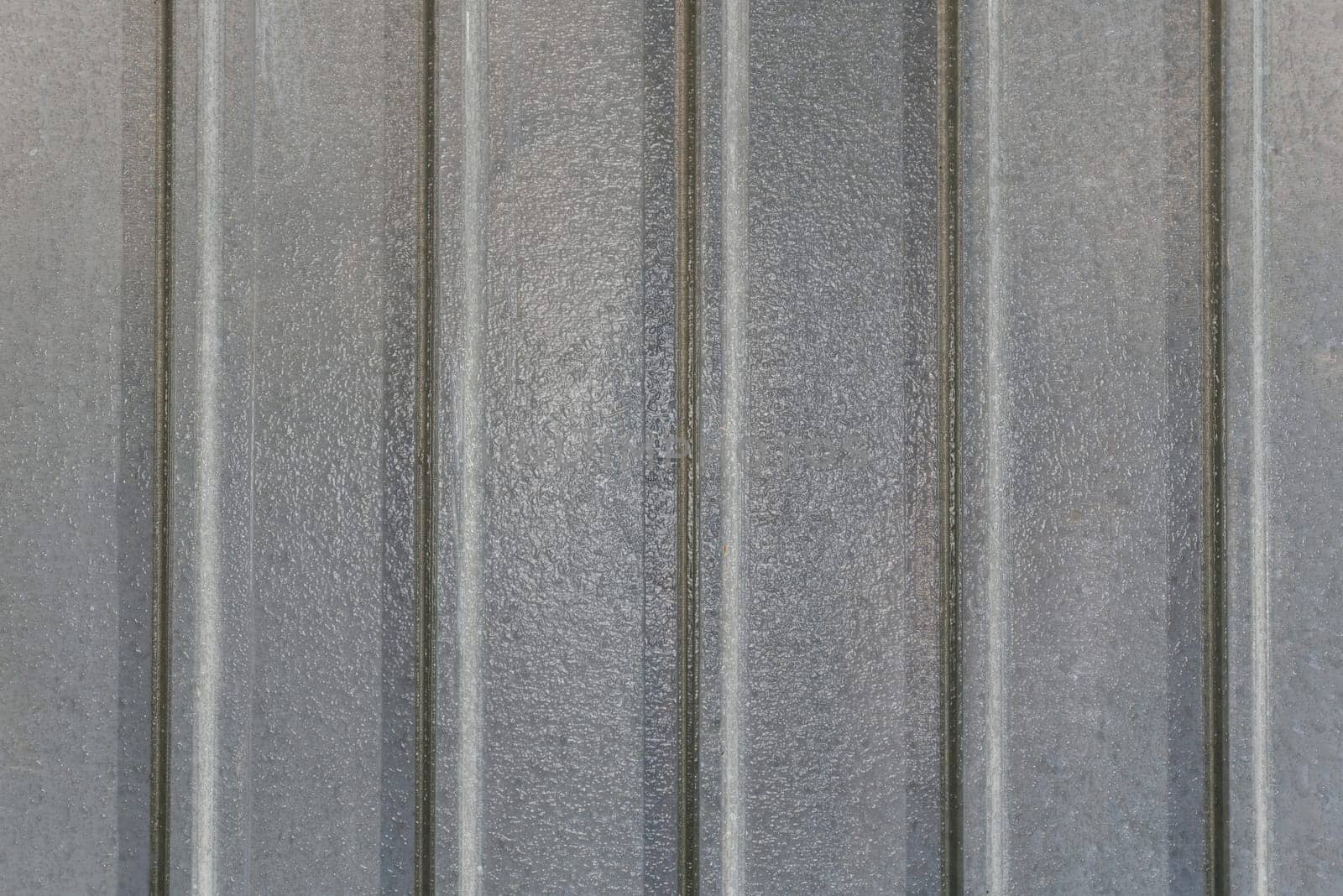 Background image of gray vertical metal plates with a glossy surface in close-up