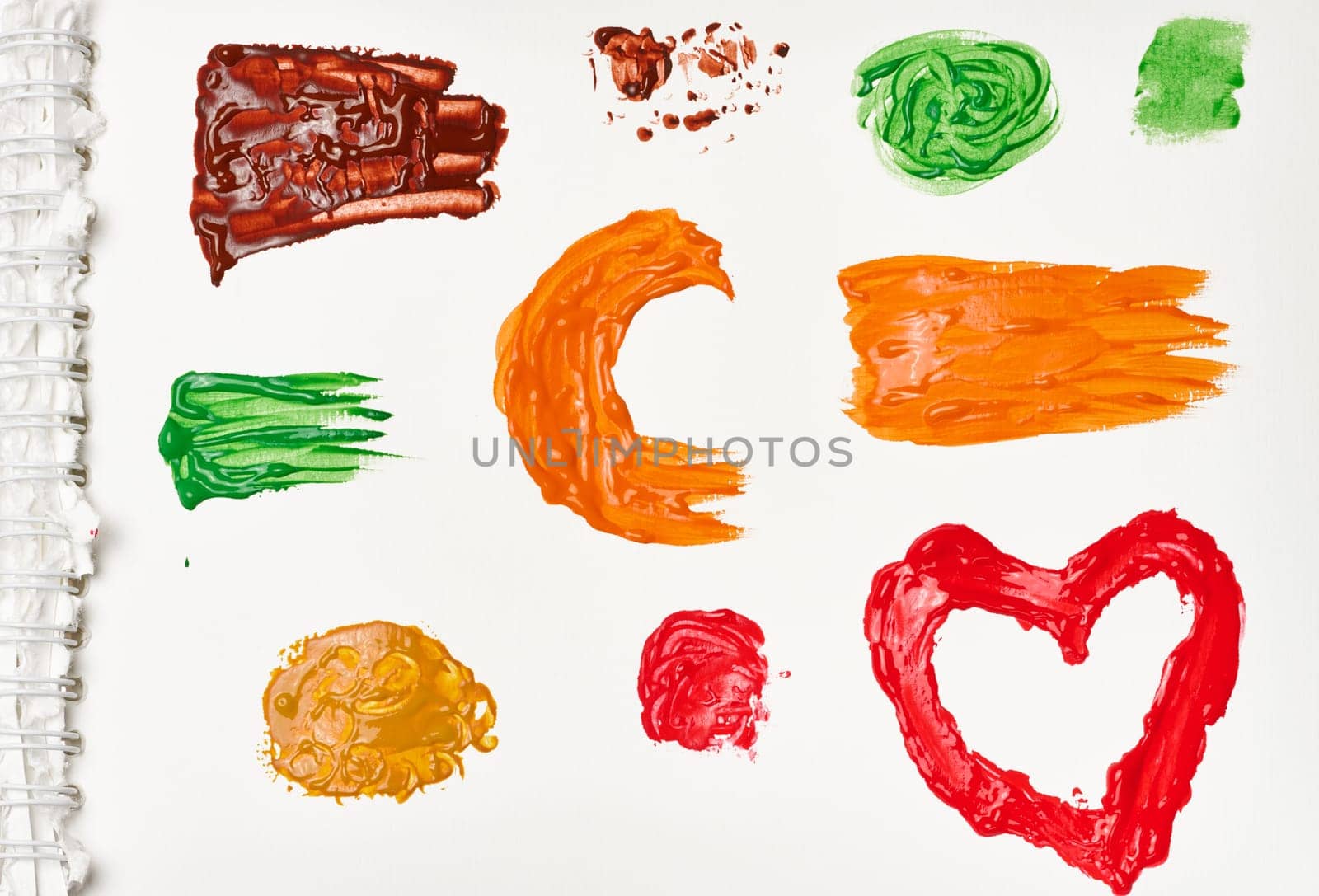 Brush strokes, drops of multi-colored oil paint on a white background, top view